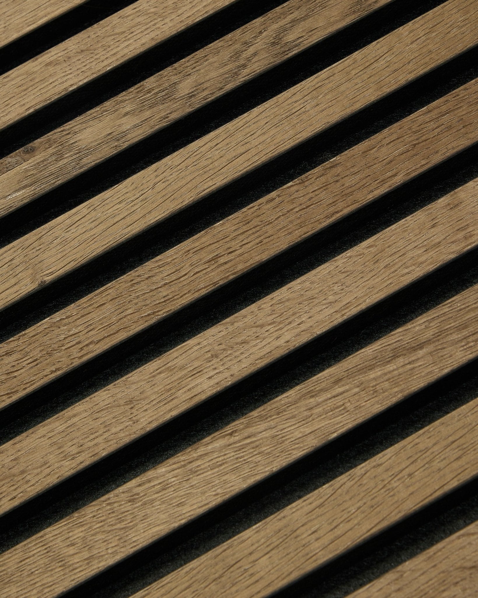 Ukośne drewniane lamele z ciemnymi przerwami tworzą pasy na panelu Rustic Akupixel Grey Oak Panel akustyczny od WoodUpp o wymiarach 60x60 cm, w nowoczesnym skandynawskim stylu.