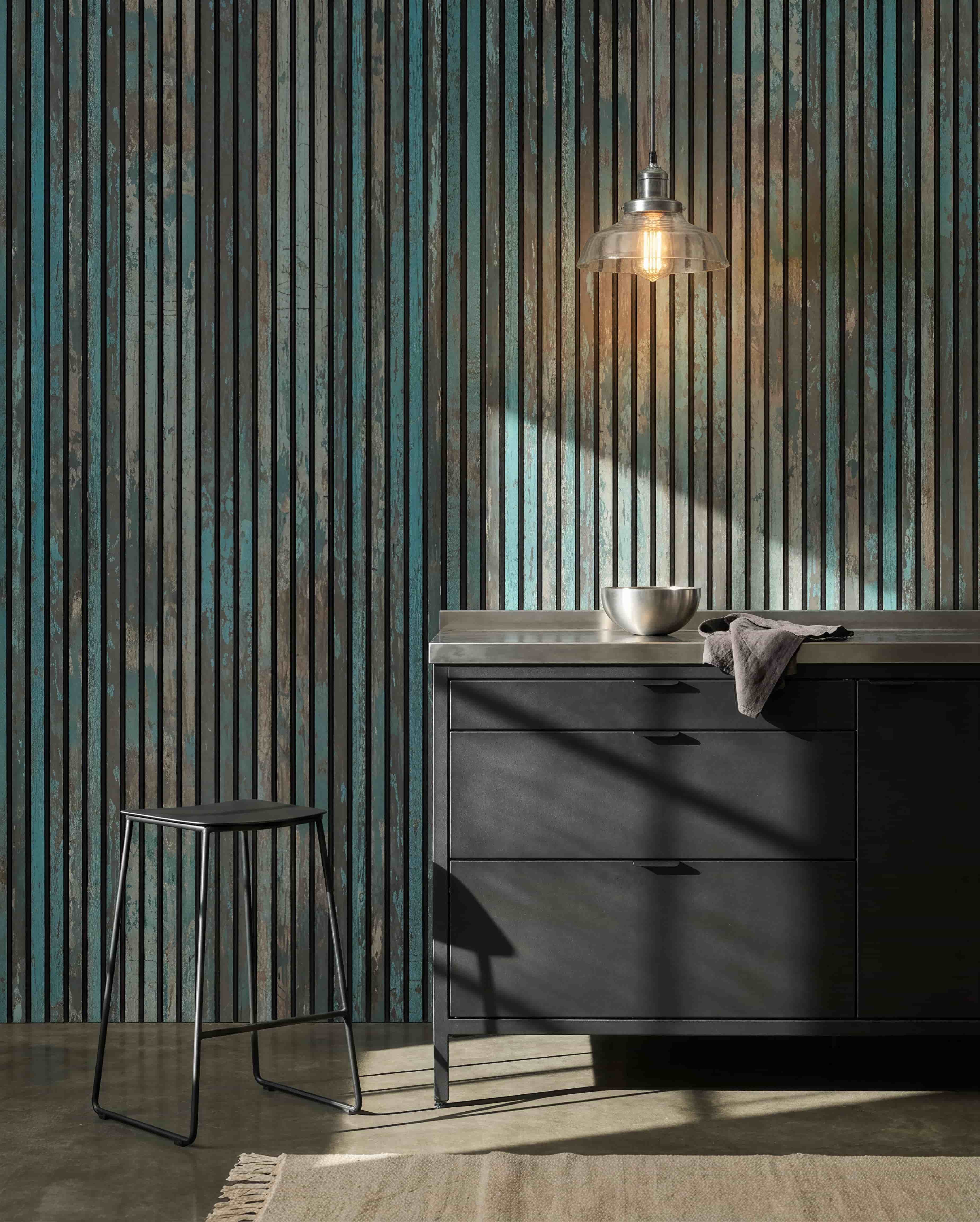Nowoczesna kuchnia z black stołkami, black szafkami, misą pod wiszącą żarówką oraz ściennym Panel akustyczny WoodUpp Akupanel Oxide Blue, który poprawia komfort akustyczny.