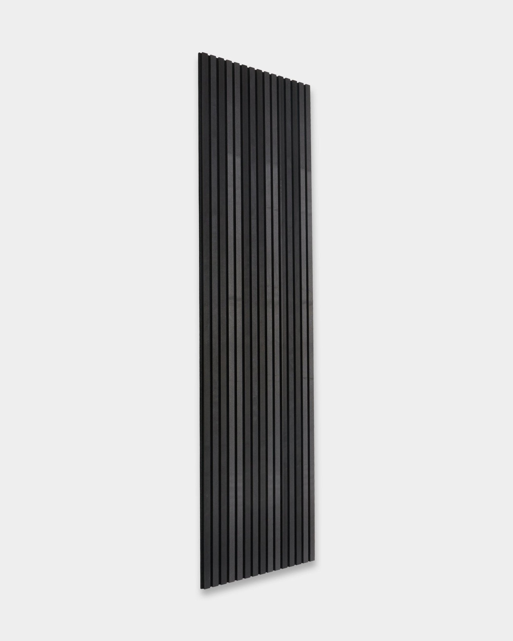 WoodUpp Akupanel Tonal Panel akustyczny w kolorze Black Ash (300x60 cm) z listwami vertical, zamontowany na gładkiej jasnoszarej ścianie, pokazuje minimalistyczny skandynawski design.