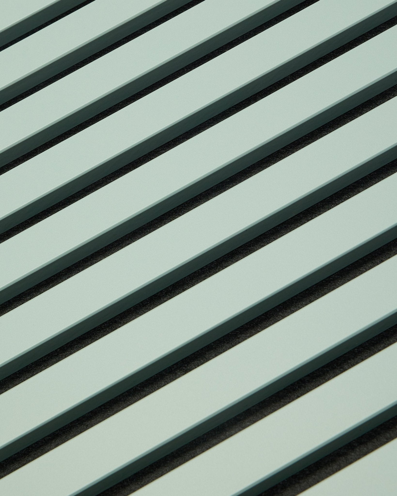 Hue | Akupanel / Cloud od WoodUpp przedstawia jasnozielone akustyczne panele drewniane z lamelami vertical i ciemnymi szczelinami, tworząc geometryczny wzór wspierający pochłanianie dźwięku.