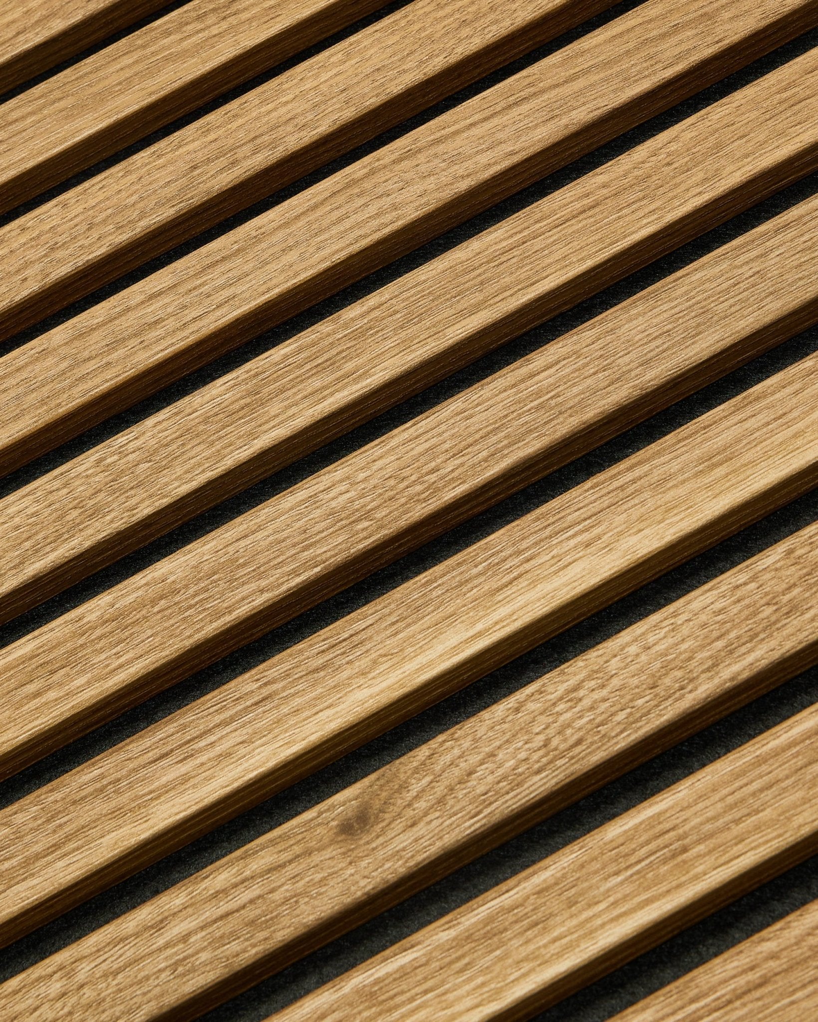 Essential Akupanel Panel akustyczny w kolorze English Oak od WoodUpp, 240 x 60 cm, z równomiernie rozmieszczonymi ukośnymi listwami na ciemnym tle.