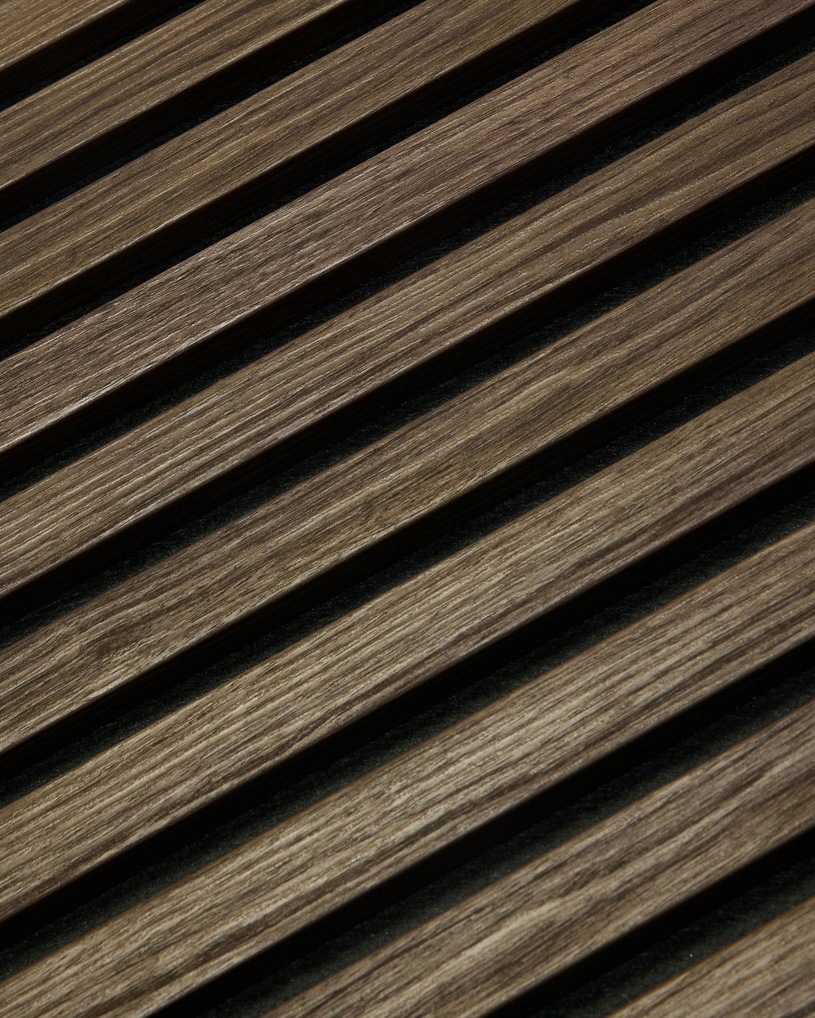 Zbliżenie na WoodUpp Essential Akupanel w kolorze Black Oak, 240 x 60 cm, z ukośnymi drewnianymi listwami o widocznym usłojeniu, zaprojektowanymi z myślą o poprawie akustyki.