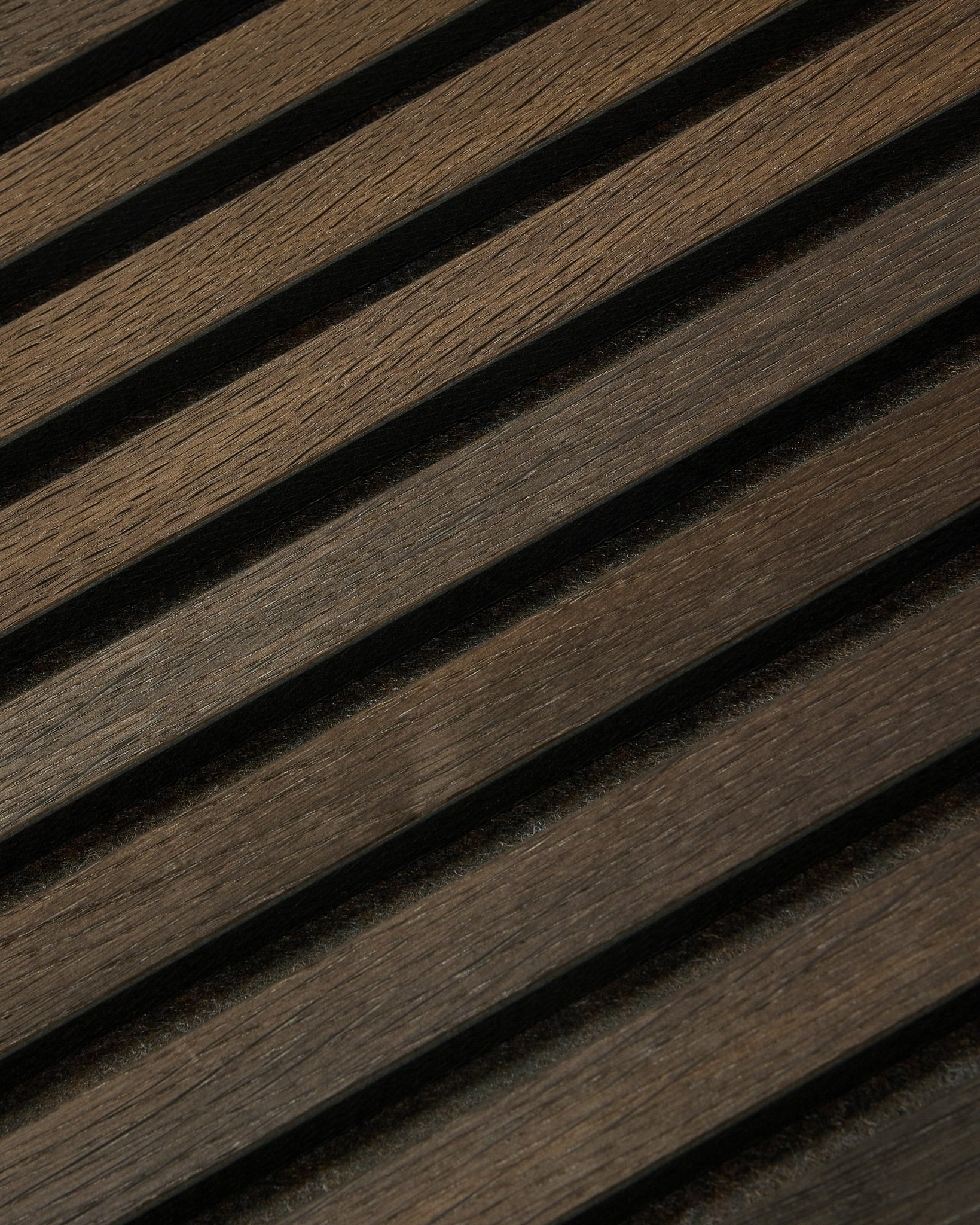 Zbliżenie na Tonal Akupanel Panel akustyczny w kolorze Smoked Oak (240 x 60 cm) od WoodUpp, z ukośnymi, fakturowanymi listwami w nordyckim, skandynawskim stylu.
