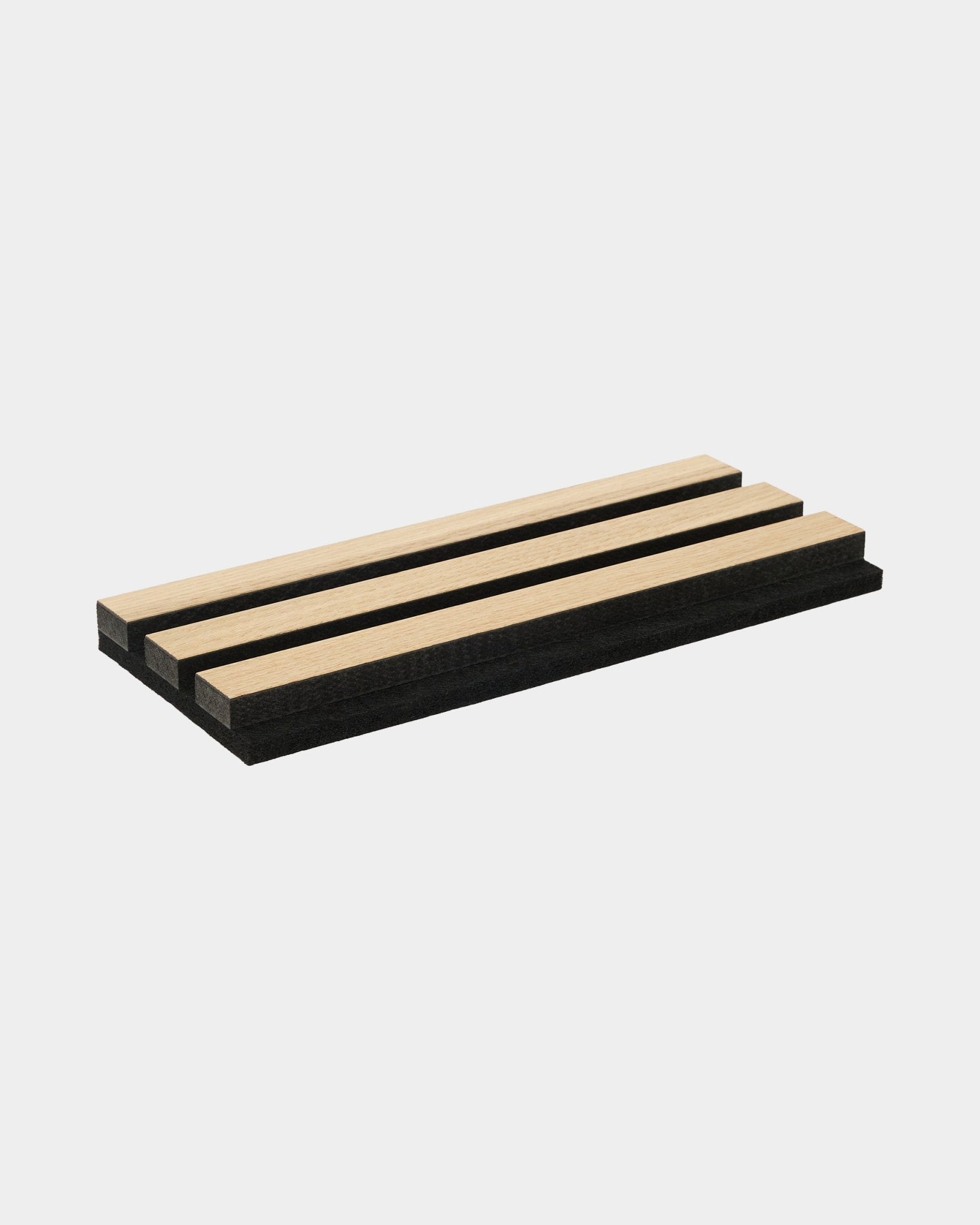 Próbnik prezentujący akustyczne lamele z klasycznego dębu i MDF w kolorze black, z podkładem filcowym w kolorze black, ułożony na jednolitym białym tle.
