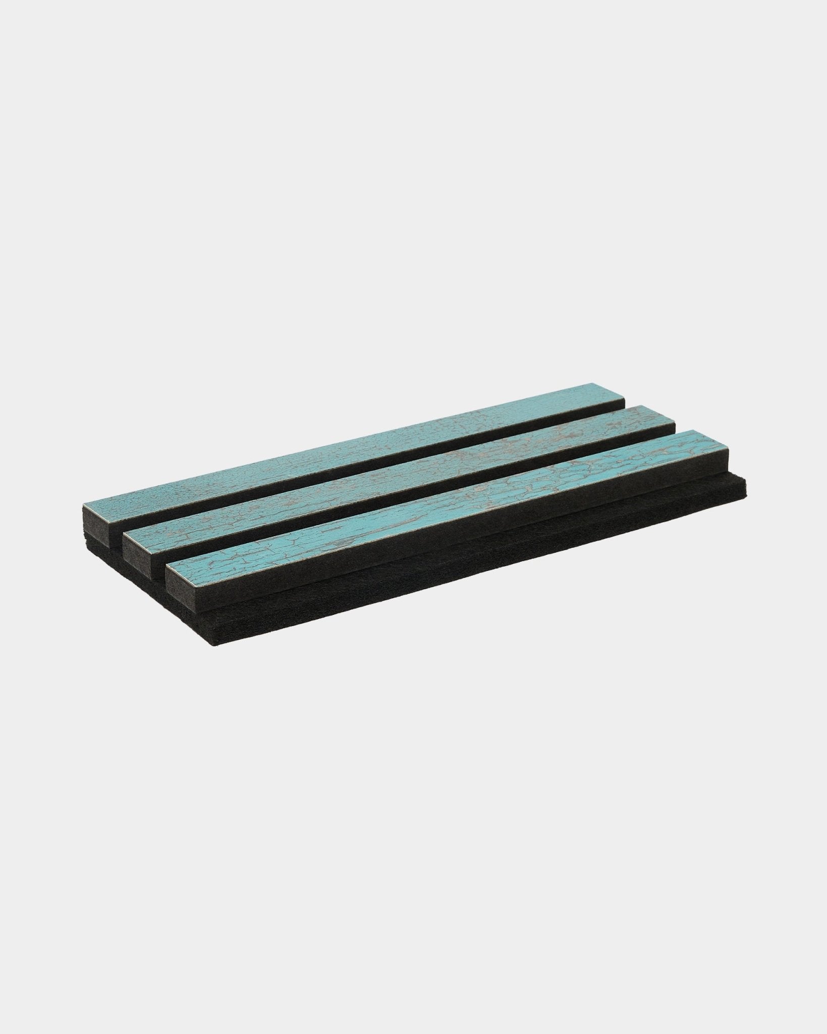 Trzy piankowe panele Rebel w kolorze Blue Oxide od WoodUpp ułożono równolegle na czystej, białej powierzchni; zaprojektowane jako akustyczne akcesoria do nordyckich wnętrz.