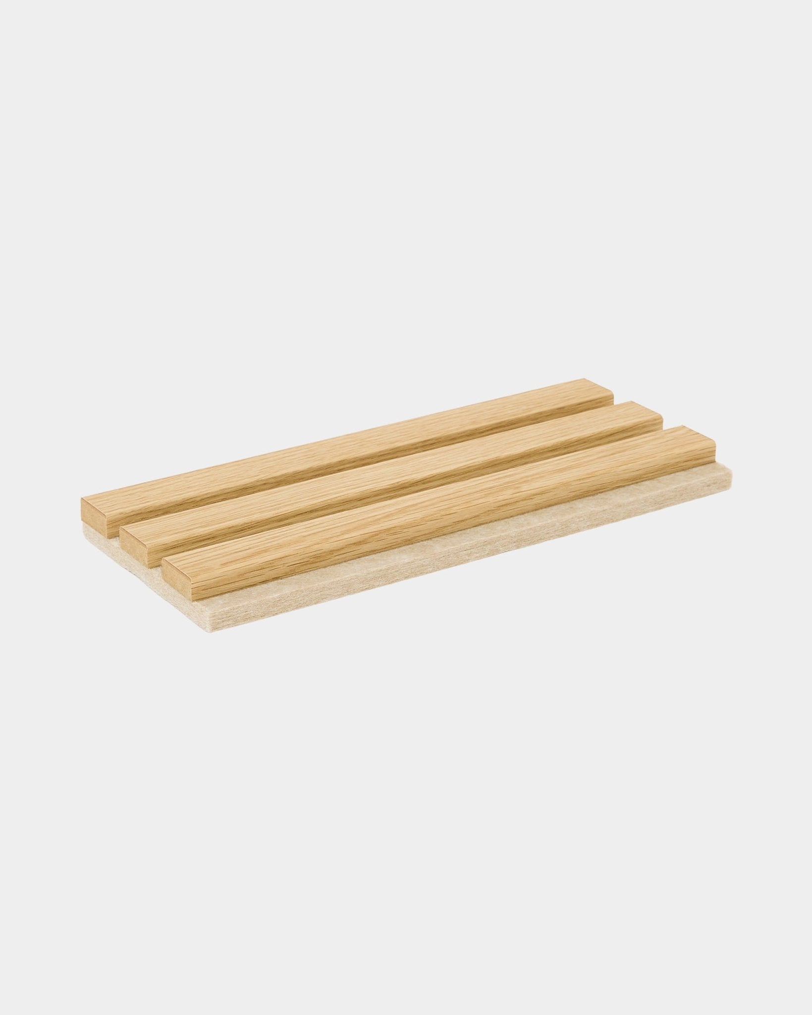 Próbka Akupanel w wykończeniu Southern Oak z filcem beige od WoodUpp, pokazana na drewnianej tacy z lamelami zaprojektowanej do prezentacji próbek akustycznych paneli drewnianych.