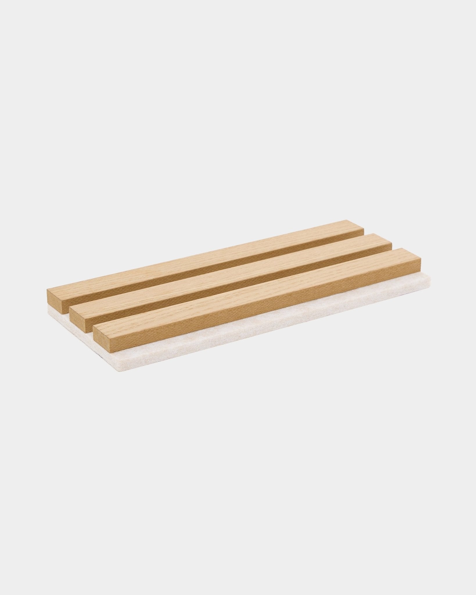 Prostokątna drewniana mydelniczka z trzema listewkami, zaprojektowana jako uzupełnienie próbek WoodUpp Akupanel w kolorze Natural Wood lub Classic Oak z jasnym filcem beige.