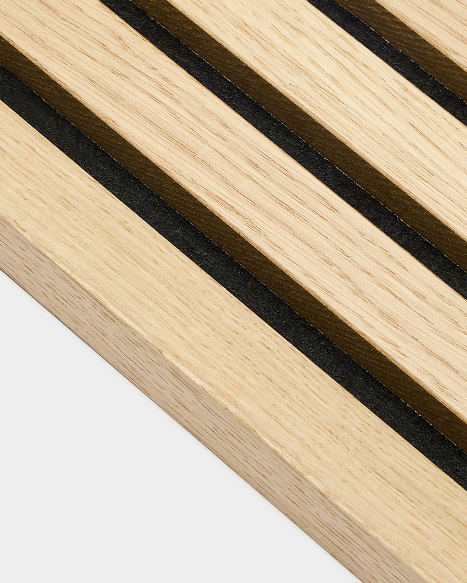 Zbliżenie na końcową lamelę WoodUpp Akupanel Classic Oak o grubości 2,2 cm, z równoległymi pasami black i brown, charakterystycznymi dla nordyckich paneli akustycznych.