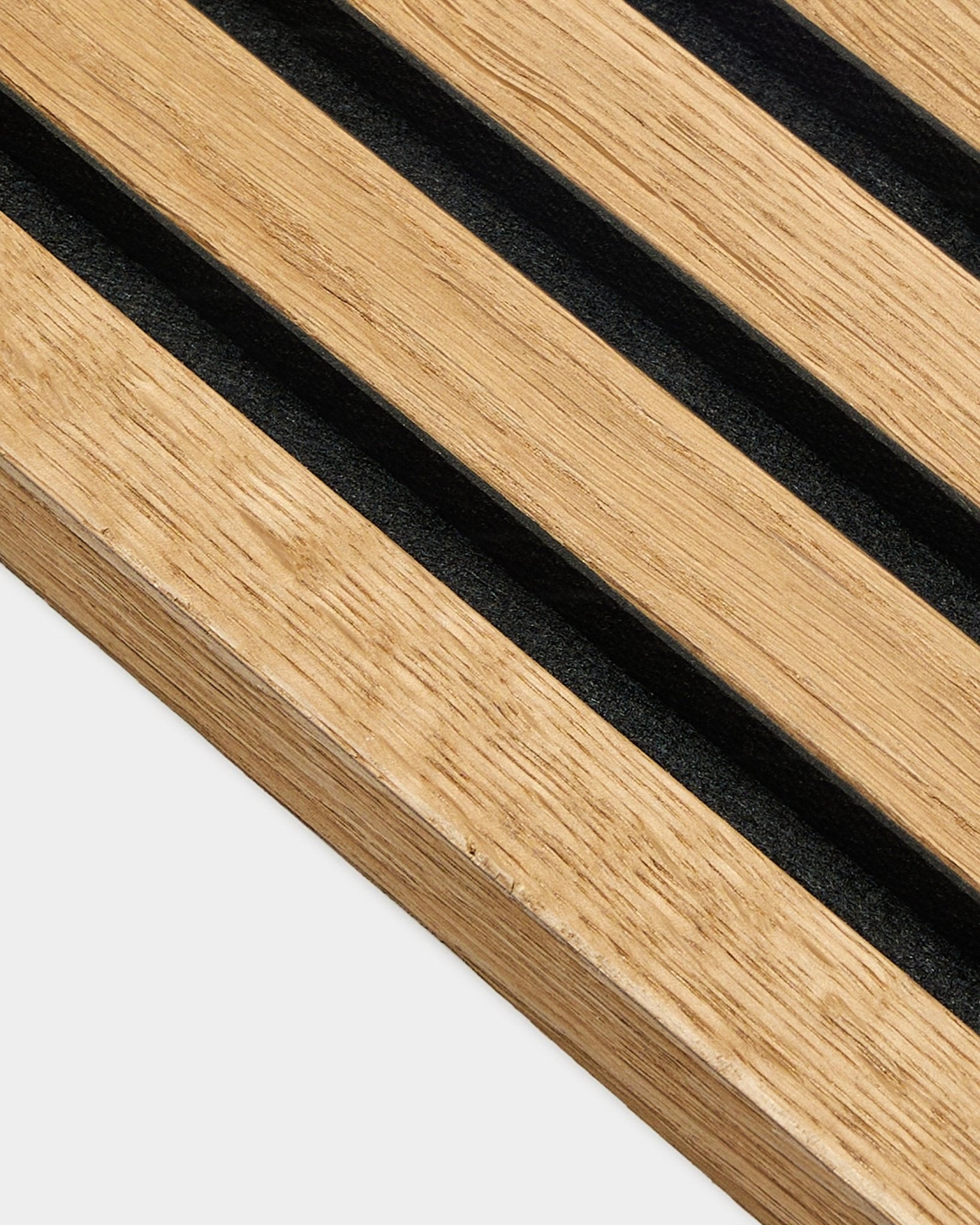Zbliżenie na panel z lamelą końcową WoodUpp w kolorze Rustic Brown Oak (2,2 cm), zaprojektowany do montażu akustycznego Akupanel, z równomiernie rozstawionymi lamelami na jasnej ścianie.