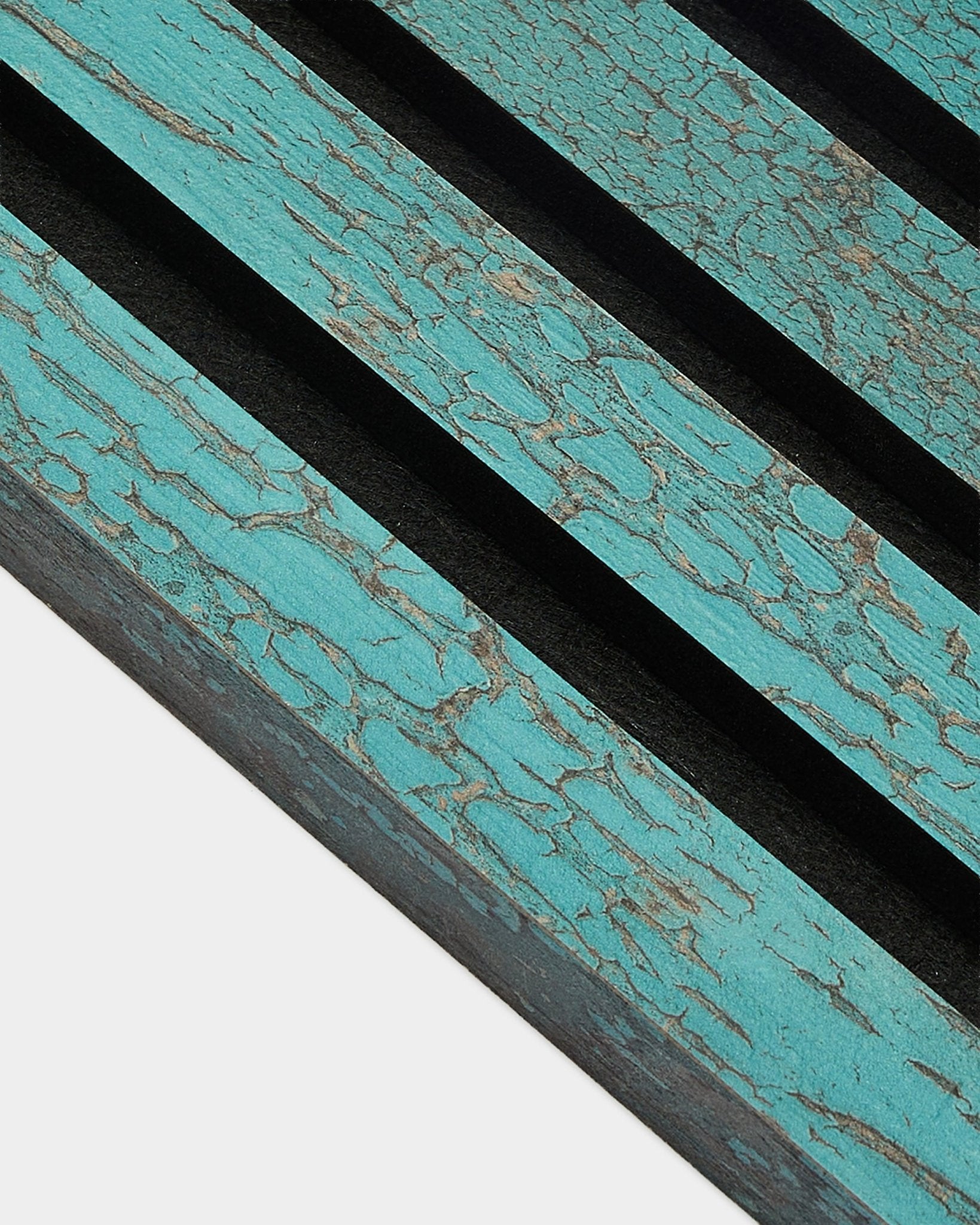Zbliżenie na końcową lamelę WoodUpp Akupanel w kolorze Oxide Blue, 2,2 cm Panel akustyczny, z postarzaną nordycką fakturą i wyraźnymi ukośnymi black rowkami.