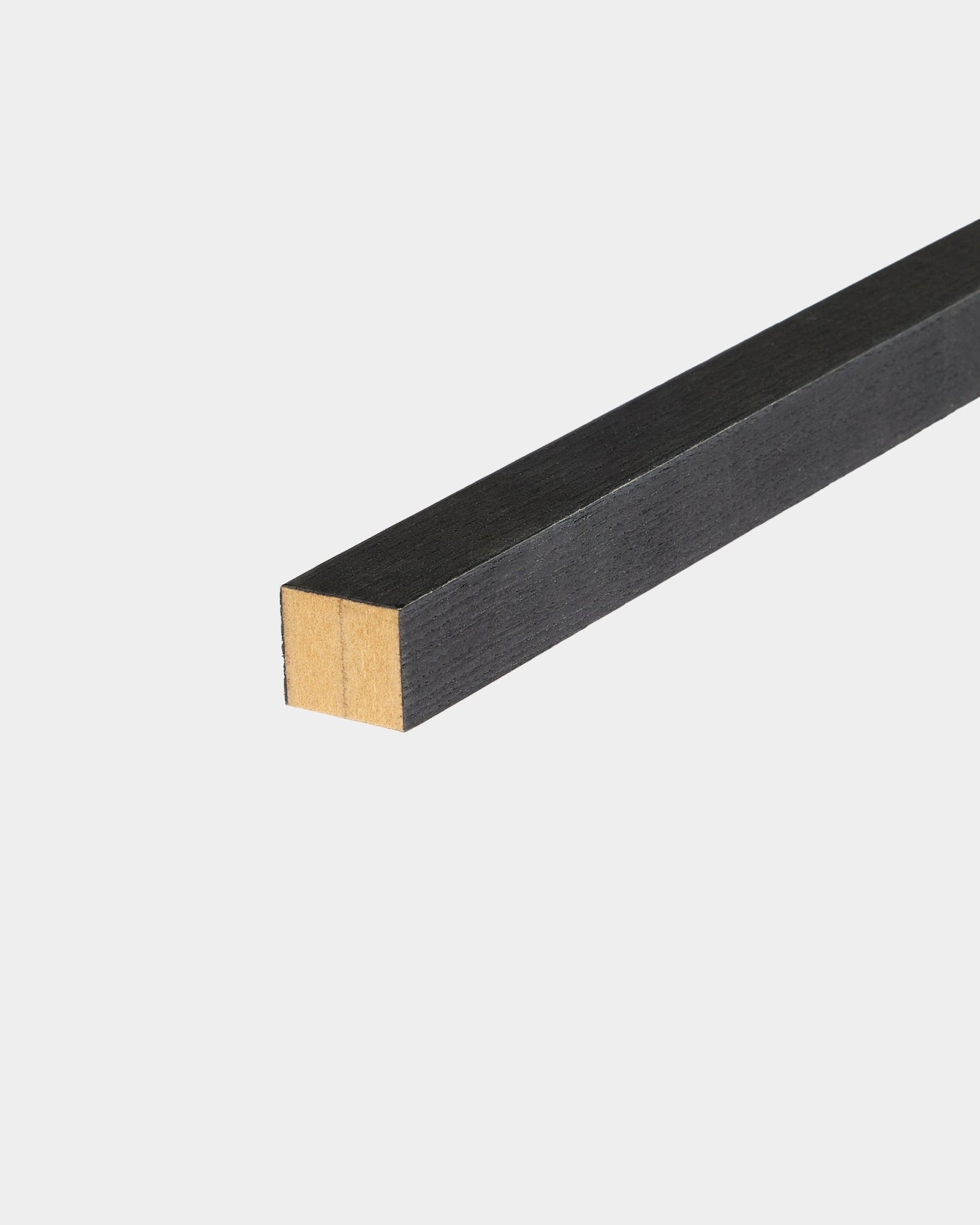 WoodUpp Black listwa końcowa Ash, 2,2 cm, zaprojektowana do montażu Akupanel Panel akustyczny, ułożona na białej powierzchni, z jednym niewykończonym końcem.