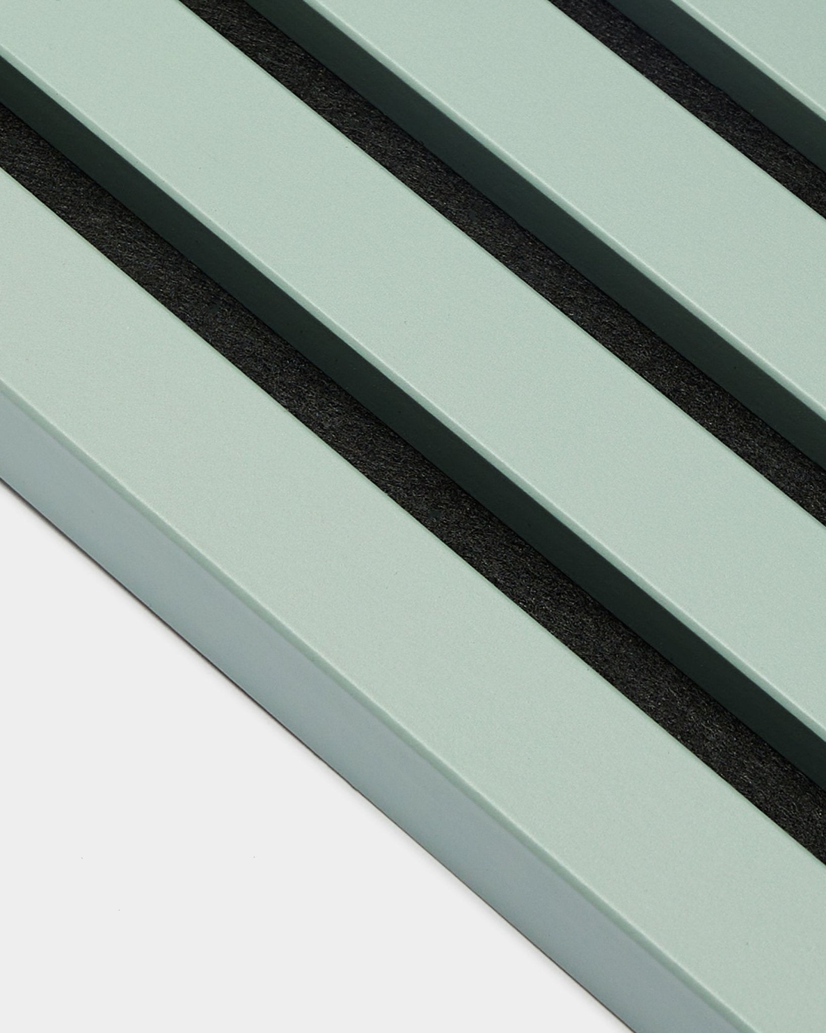 Zbliżenie na trzy równoległe, pastelowozielone listwy End Lamella / Cloud o szerokości 2,2 cm marki WoodUpp, jako część Akupanel Panel akustyczny na jasnym tle.