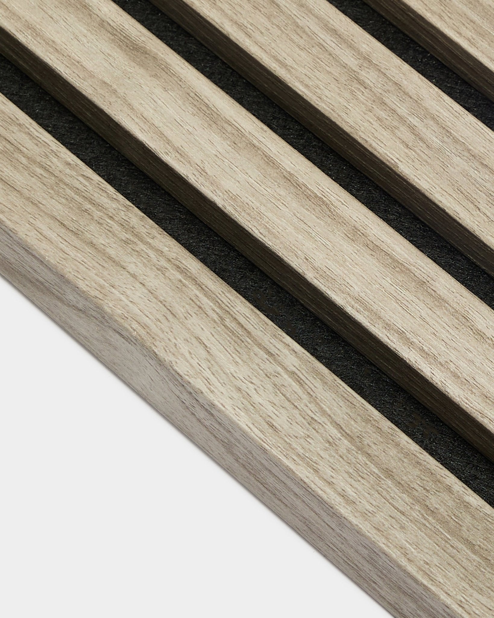 Zbliżenie na końcową lamelę WoodUpp Akupanel w kolorze Weathered Oak, 2,2 cm — jasne, nordyckie lamele akustyczne z filcowym podkładem black na białym tle.