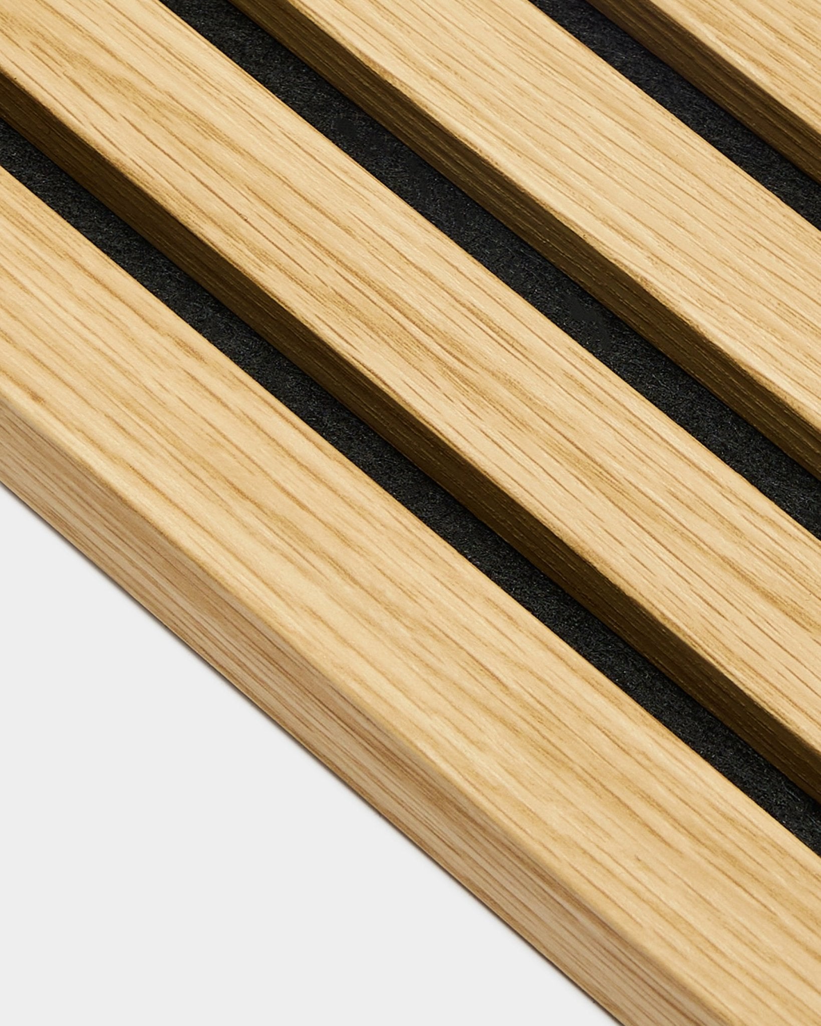 Zbliżenie na lamelę końcową WoodUpp Akupanel w kolorze Southern Oak, z listwami o szerokości 2,2 cm i szczelinami black, ułożoną ukośnie na jasnym tle grey.