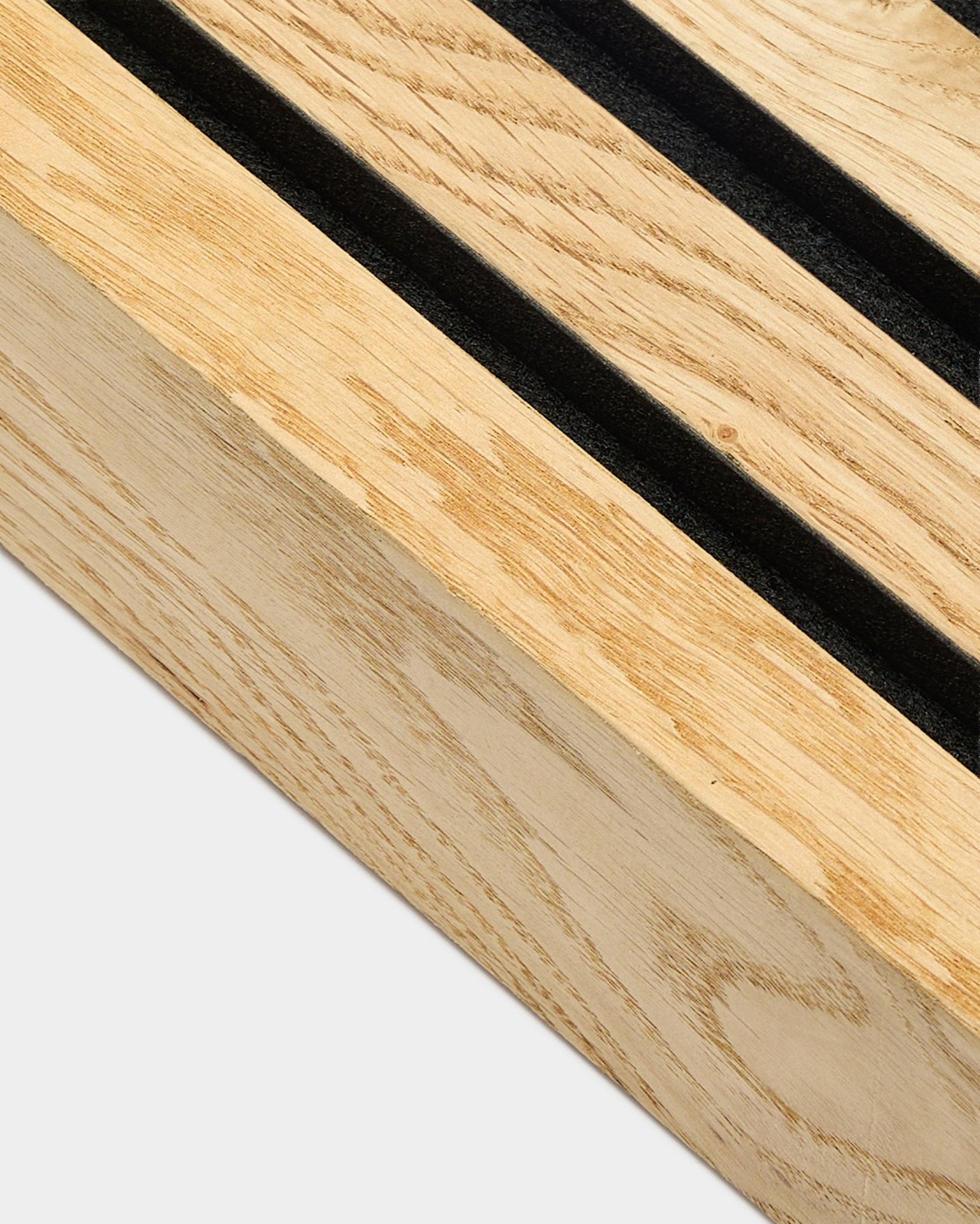 Zbliżenie na lamelę końcową WoodUpp Akupanel w kolorze Rustic Natural Oak, 6,7 cm, z równoległymi szczelinami black i ramą MDF do montażu akustycznego na ścianie.
