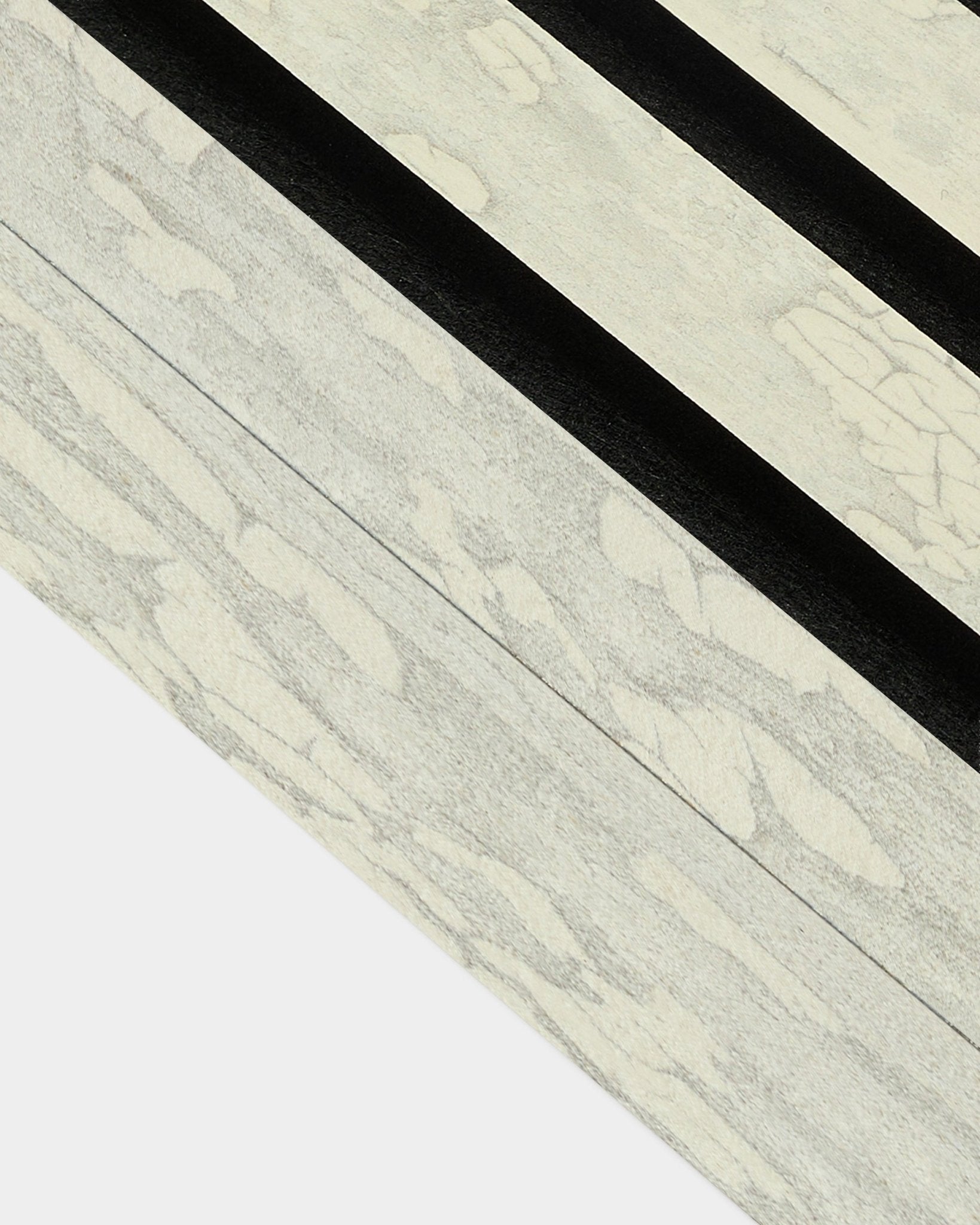 Zbliżenie na lamelę końcową Oxide White (6,7 cm) od WoodUpp do montażu z Akupanel Panel akustyczny, z wyrazistym ukośnym wzorem black w nordyckim stylu.
