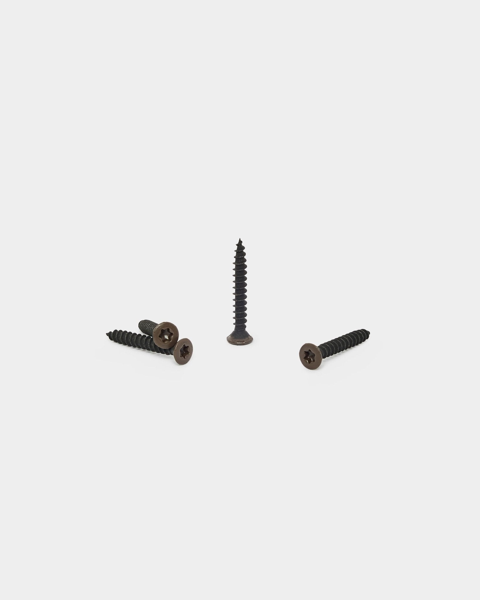 Trzy wkręty WoodUpp bronzed brown, jeden ustawiony pionowo i dwa leżące, przeznaczone do mocowania filcowego podkładu do paneli akustycznych Akupanel. Opakowanie 100 sztuk.