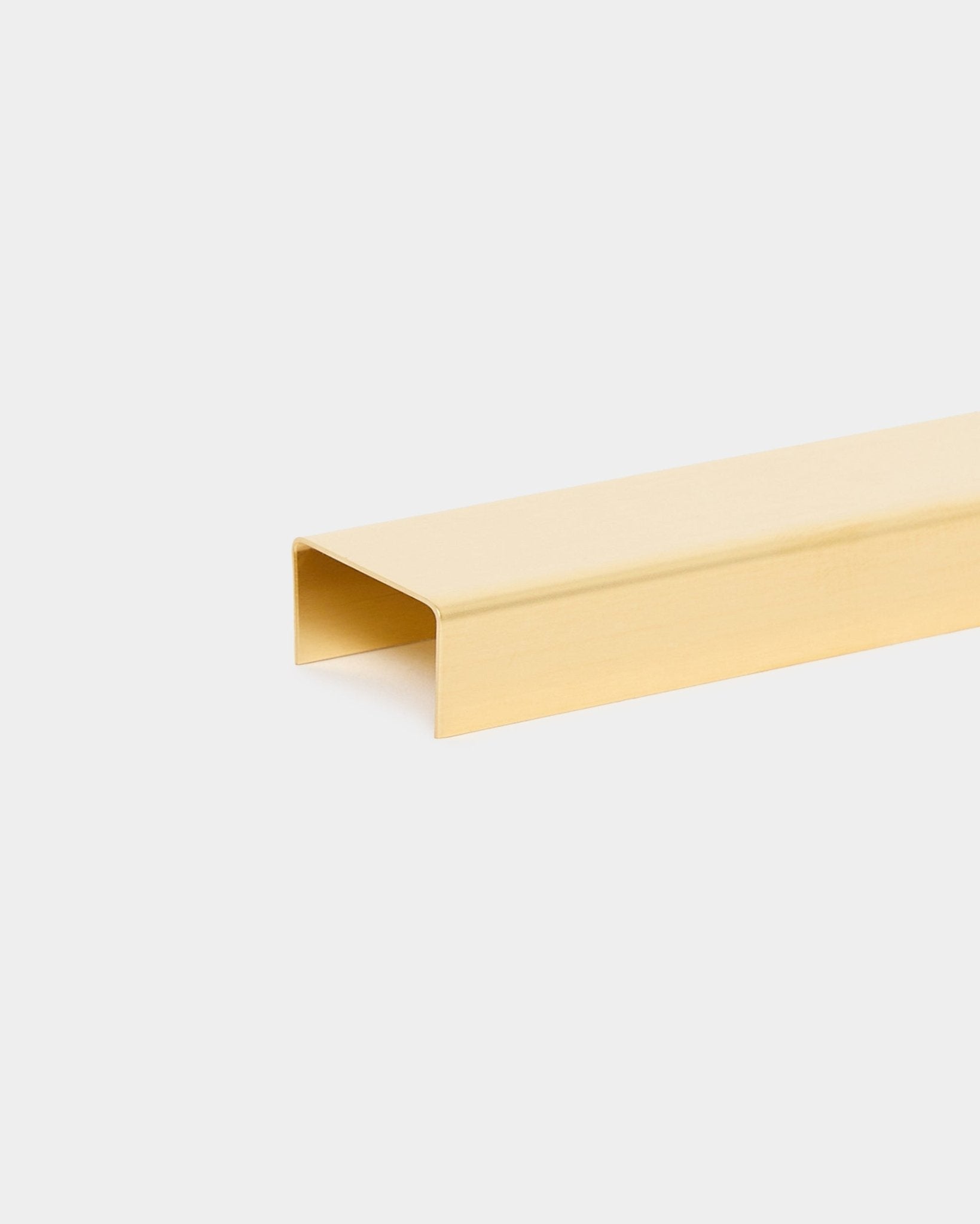 Liva | Cover / Brass, 120 cm od WoodUpp to metalowy dodatek wykończeniowy w kształcie litery U w złotym odcieniu do akustycznych paneli drewnianych, pokazany na jasnym tle.