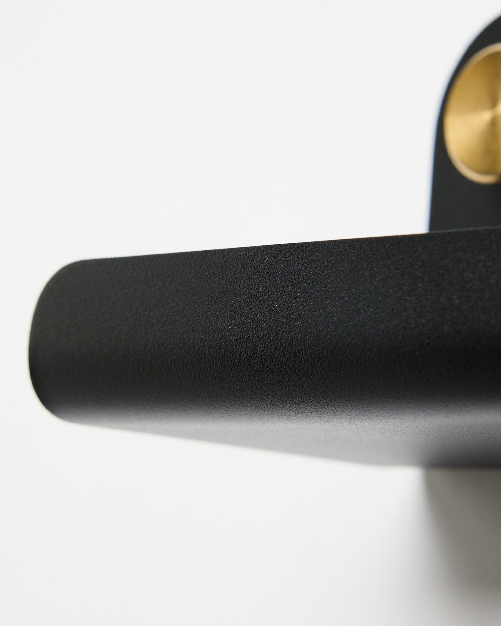 Zbliżenie na klamkę drzwi w kolorze black oraz półkę WoodUpp Norr | Narrow Shelf w kolorze black, 51,9 cm, na białym tle.