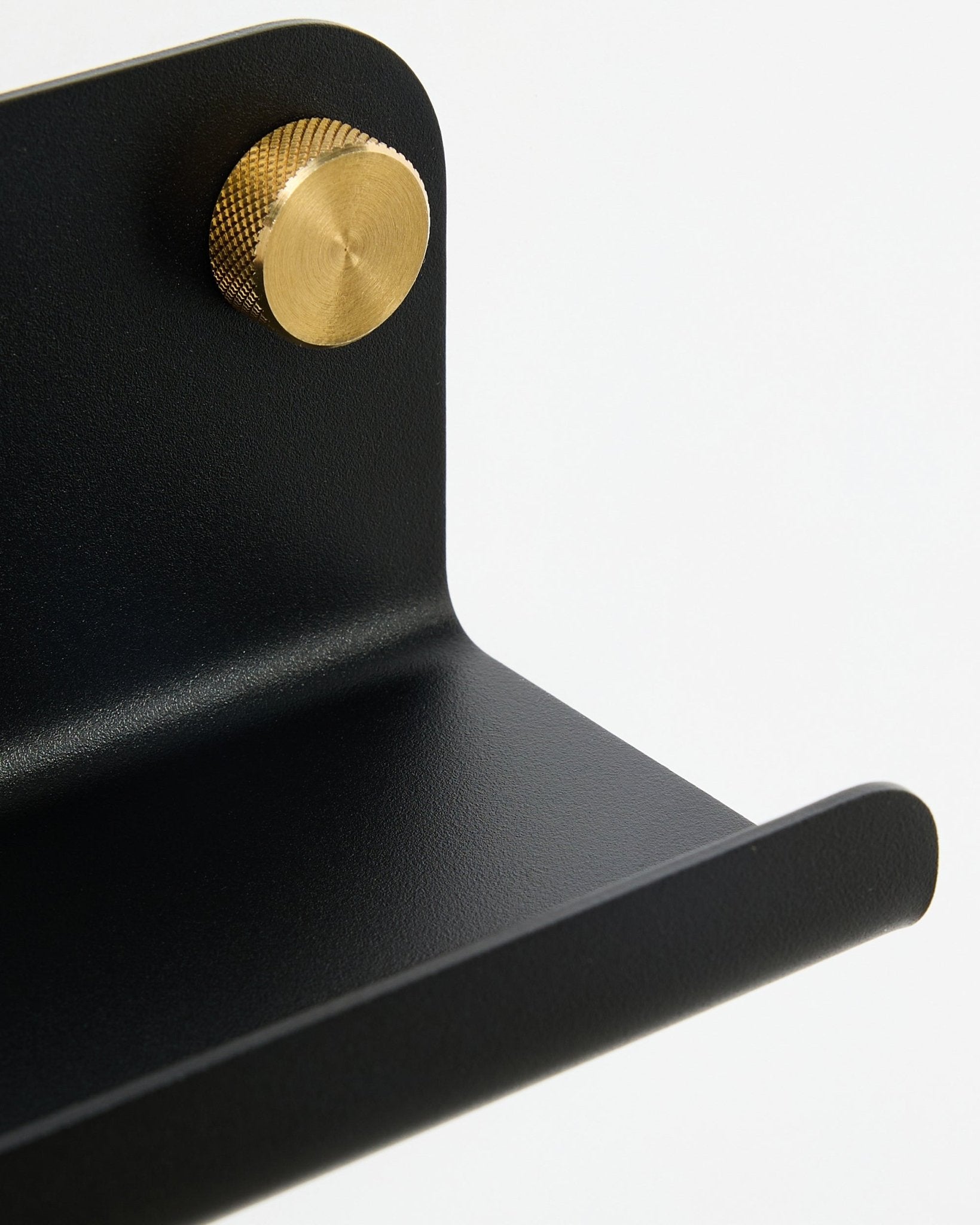 Zbliżenie na wąską półkę WoodUpp Norr, 35,9 cm, black steel z zaokrągloną krawędzią i złotym pokrętłem, pokazane na białym tle.