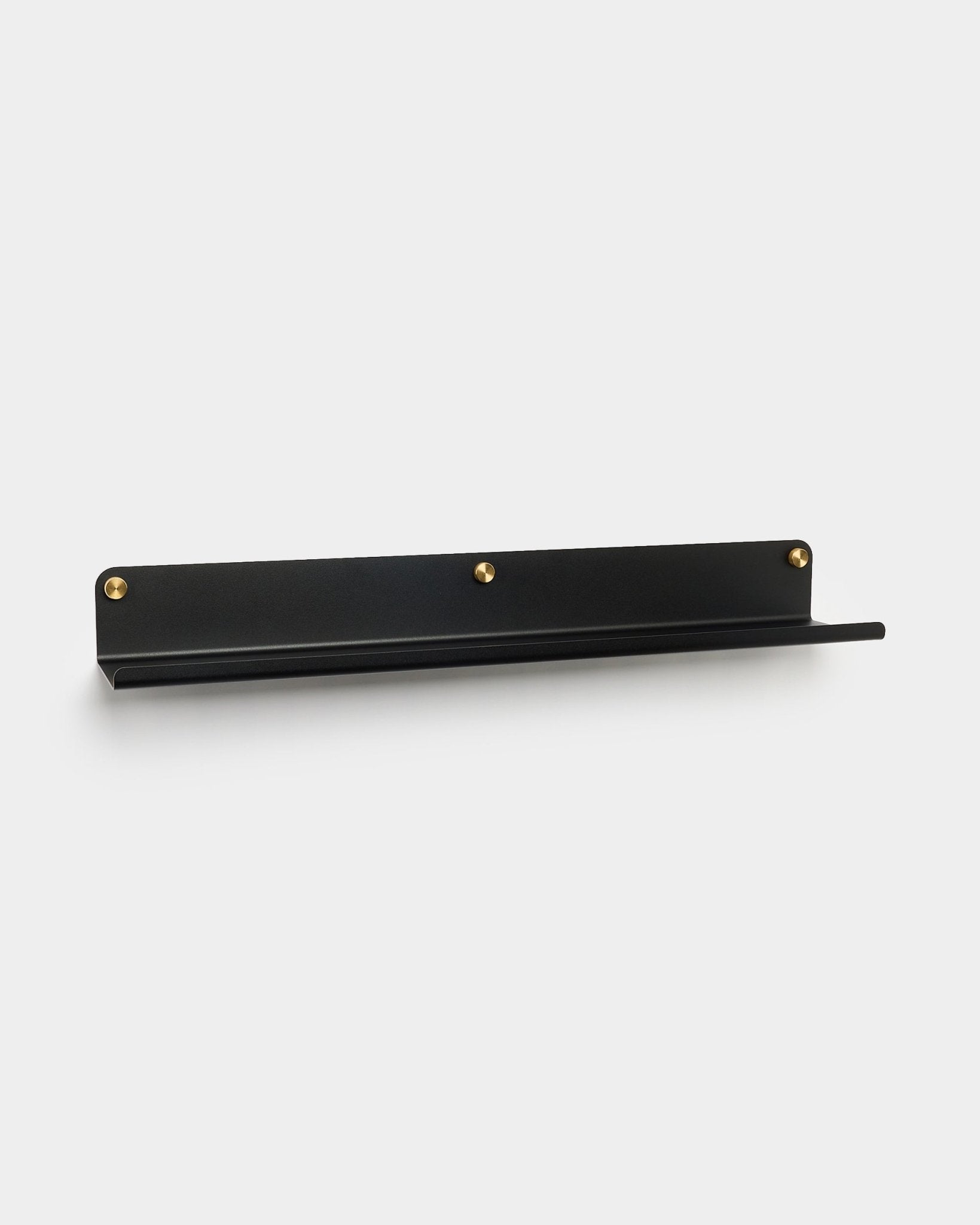 Szeroka półka Norr w kolorze black (75,9 cm) od WoodUpp, wykonana z galwanizowanego steel z trzema złotymi śrubami, akcesorium do Akupanel, pokazana na jednolitym białym tle.