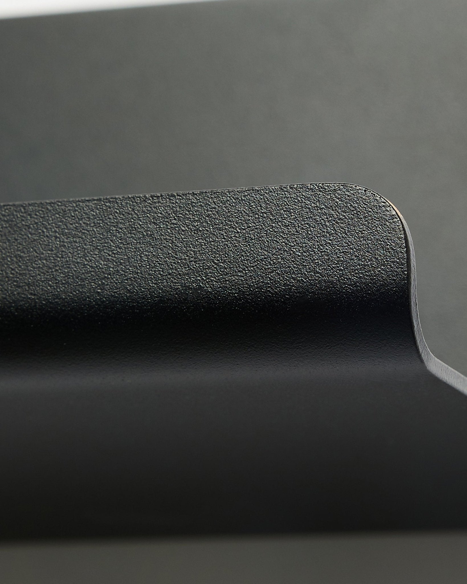 Norr | Szeroka półka od WoodUpp w kolorze black, 75,9 cm, z teksturowaną, zaokrągloną krawędzią i minimalistycznym nordyckim wzornictwem na gładkim szarym tle.