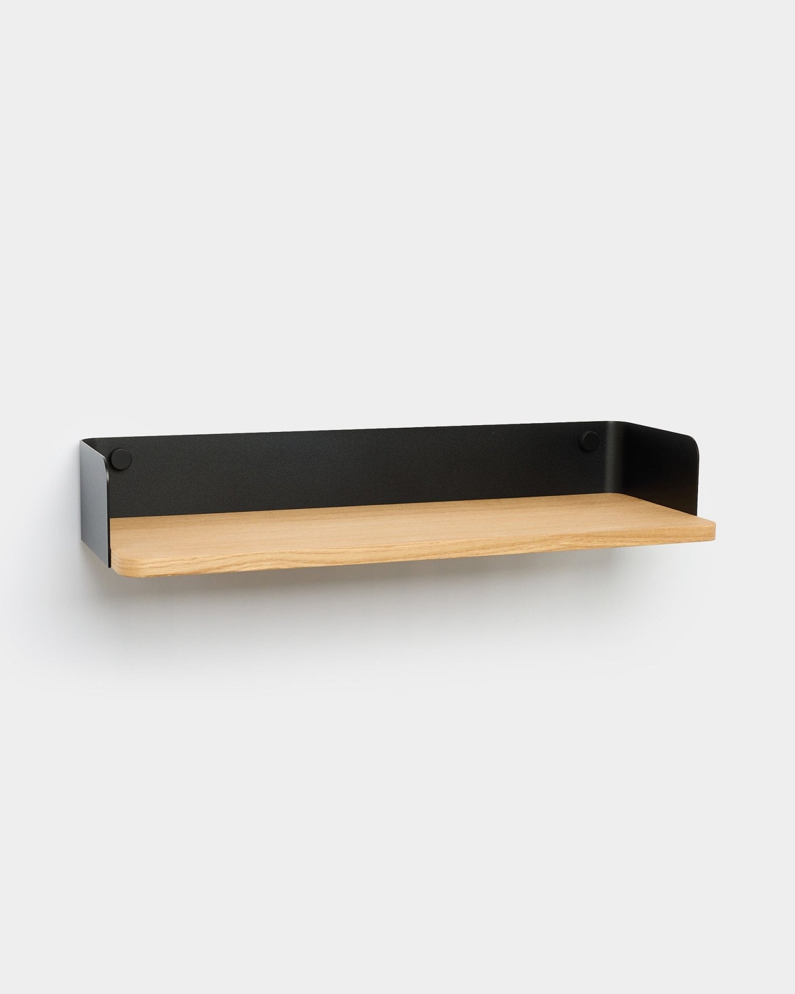 Biblioteczka Linn od WoodUpp z podstawą z jasnego drewna i metalowymi bokami black, zaprojektowana w minimalistycznym nordyckim stylu, który dobrze dopełnia nowoczesne wnętrza.