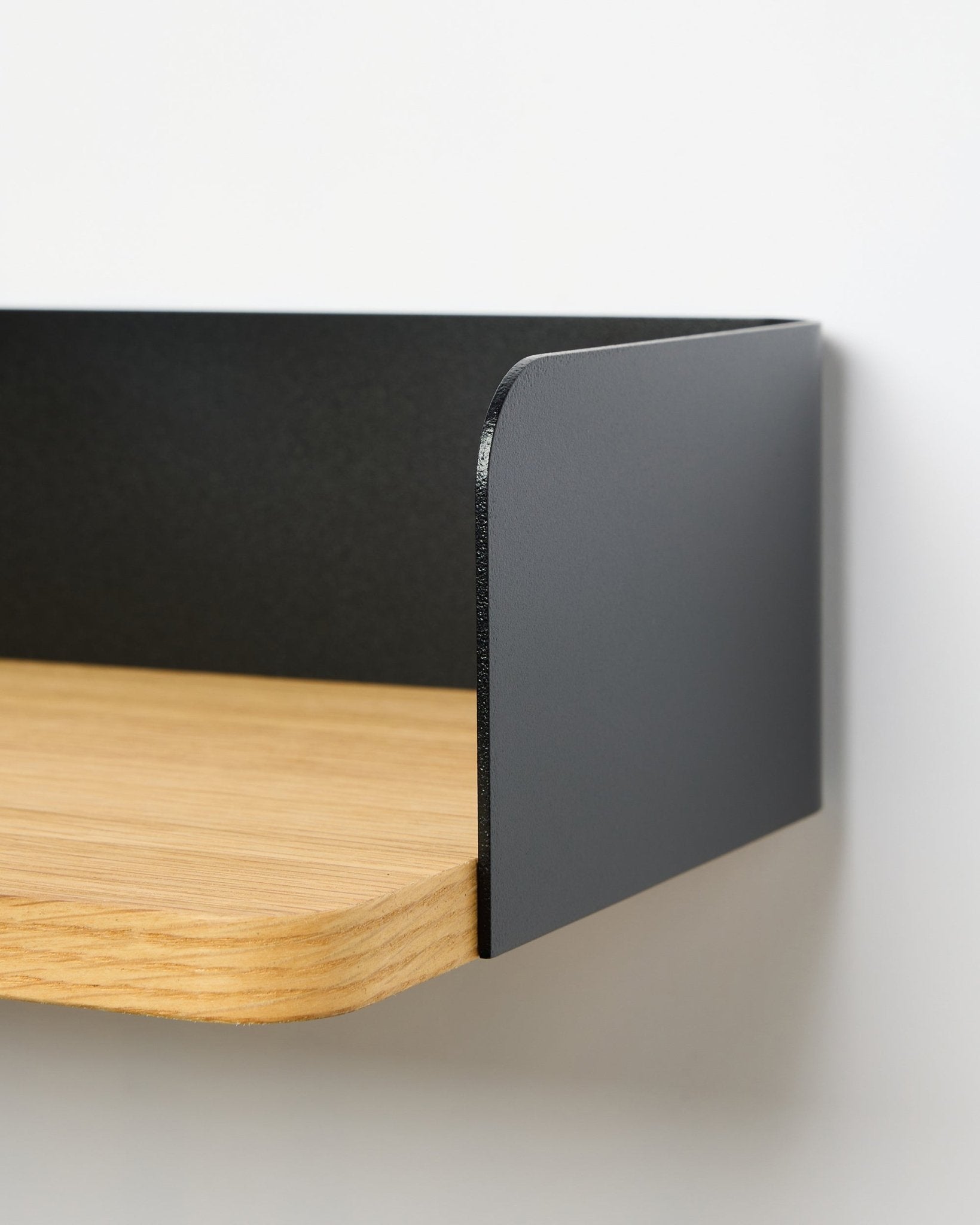 Zbliżenie na półkę na książki WoodUpp Linn w kolorze Natural Oak, o szerokości 39,9 cm, z metalowym panelem bocznym black; półka bez wiercenia na białym tle.