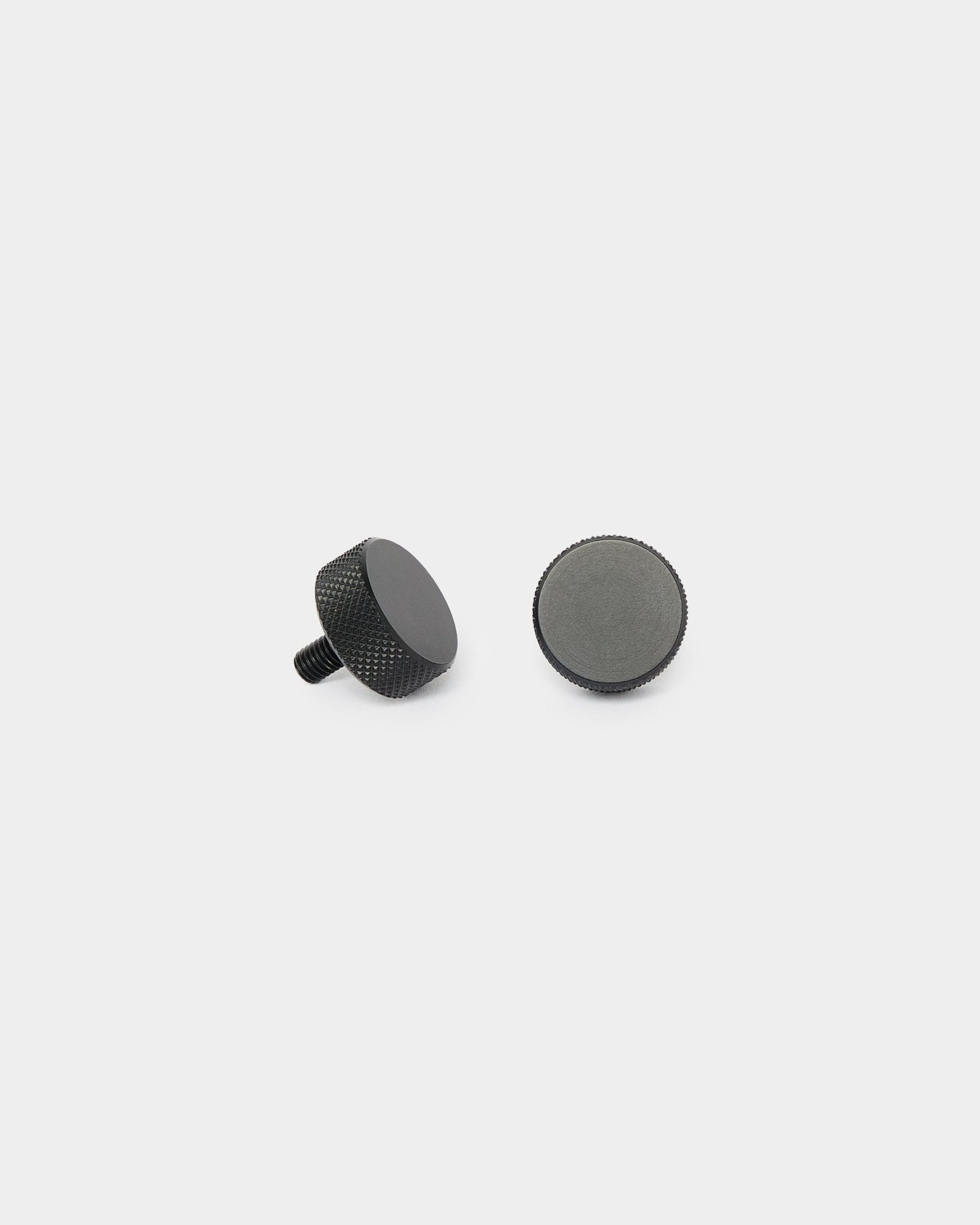 Dwie śruby WoodUpp Finger black (2 szt., M5x10 mm, 20x8,8), ustawione pionowo i leżące na boku, na jednolitym białym tle, do montażu Akupanel.