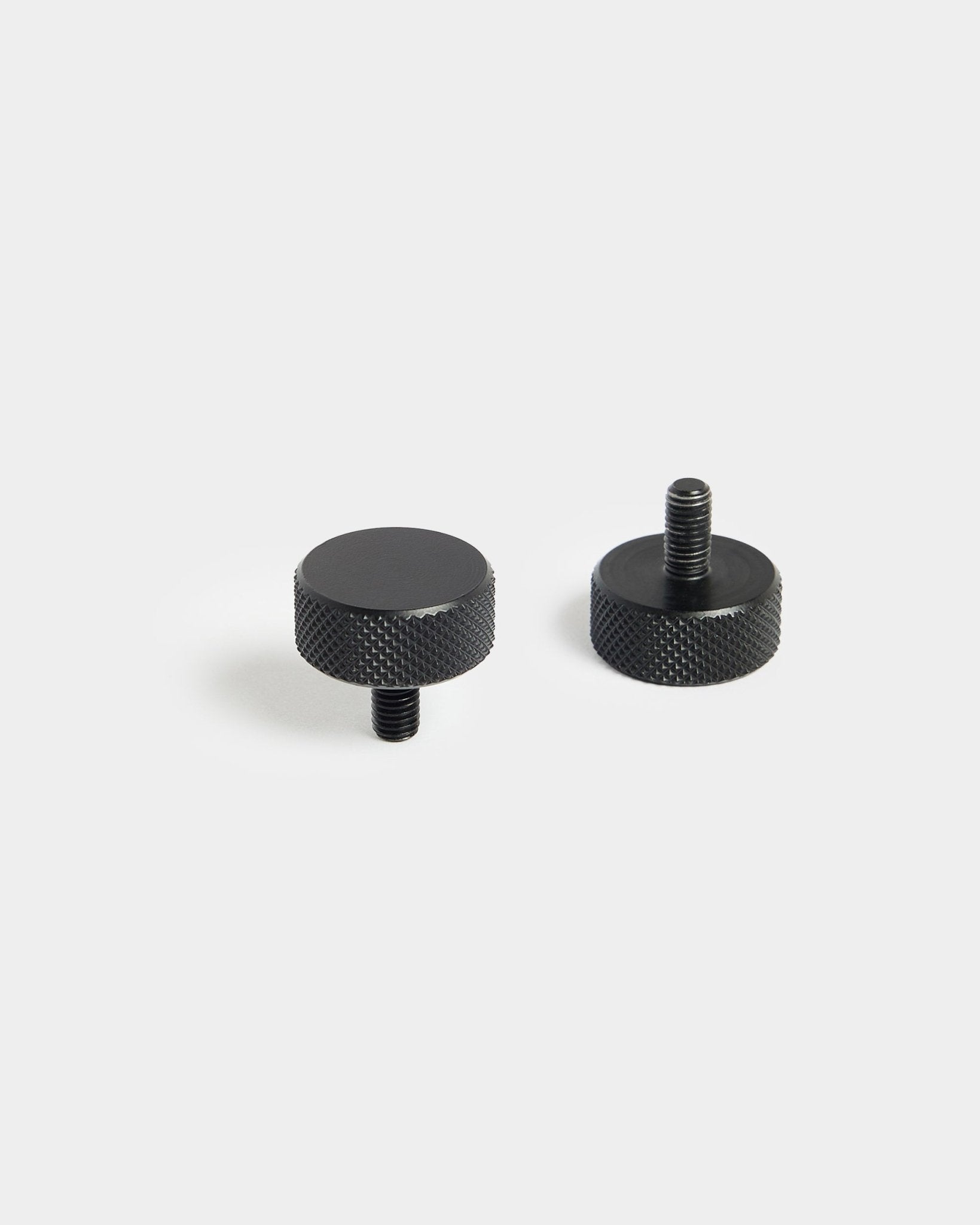 Para śrub WoodUpp Finger black (M5x10 mm, 20x8,8) z radełkowanymi krawędziami, zaprojektowanych do użycia z akcesoriami Panel akustyczny, na jednolitym białym tle.