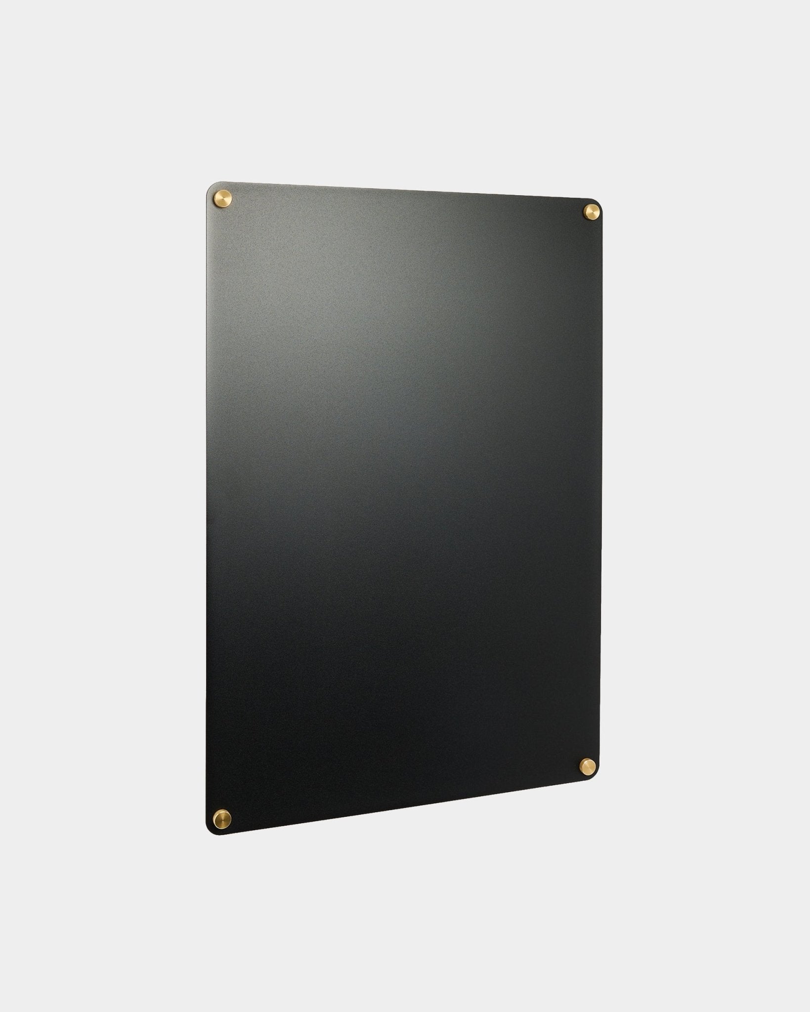 Large black Norr tablica magnetyczna od WoodUpp, część kolekcji akcesoriów CREATE, zamontowana na jasnoszarej ścianie.