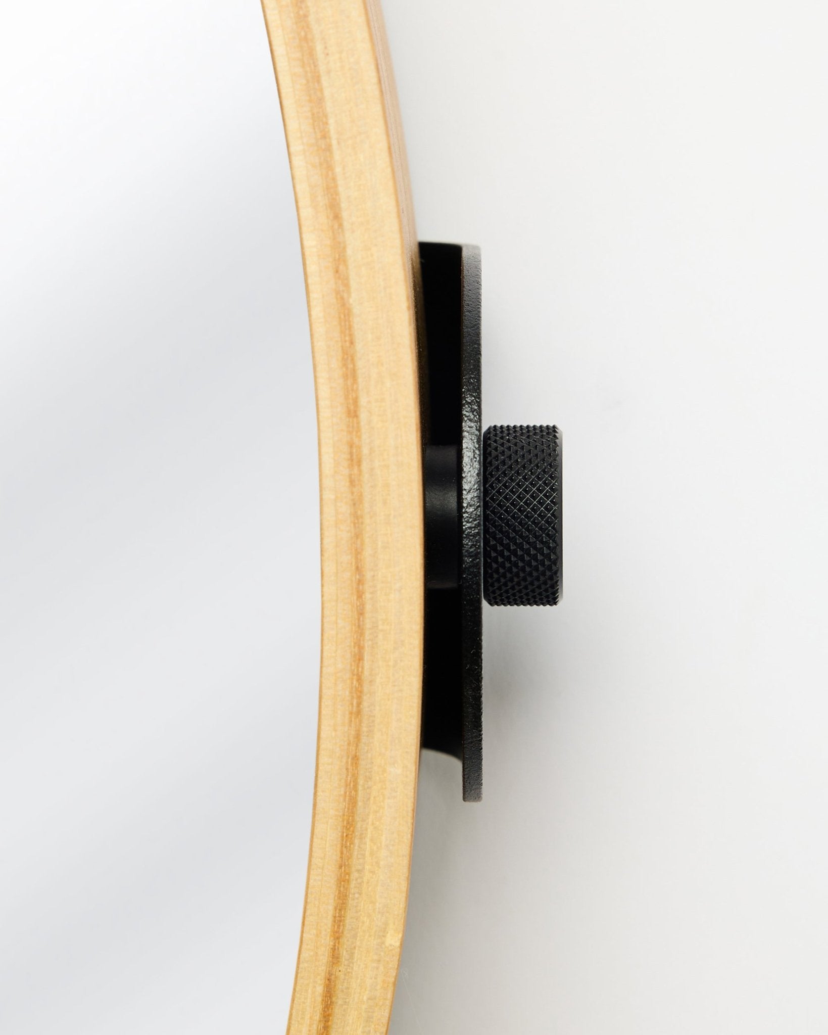 Zbliżenie z boku na WoodUpp Linn | Mirror w kolorze Natural Oak, z okrągłą dębową ramą i metalowym pokrętłem black, akcesorium do akustycznych paneli drewnianych.