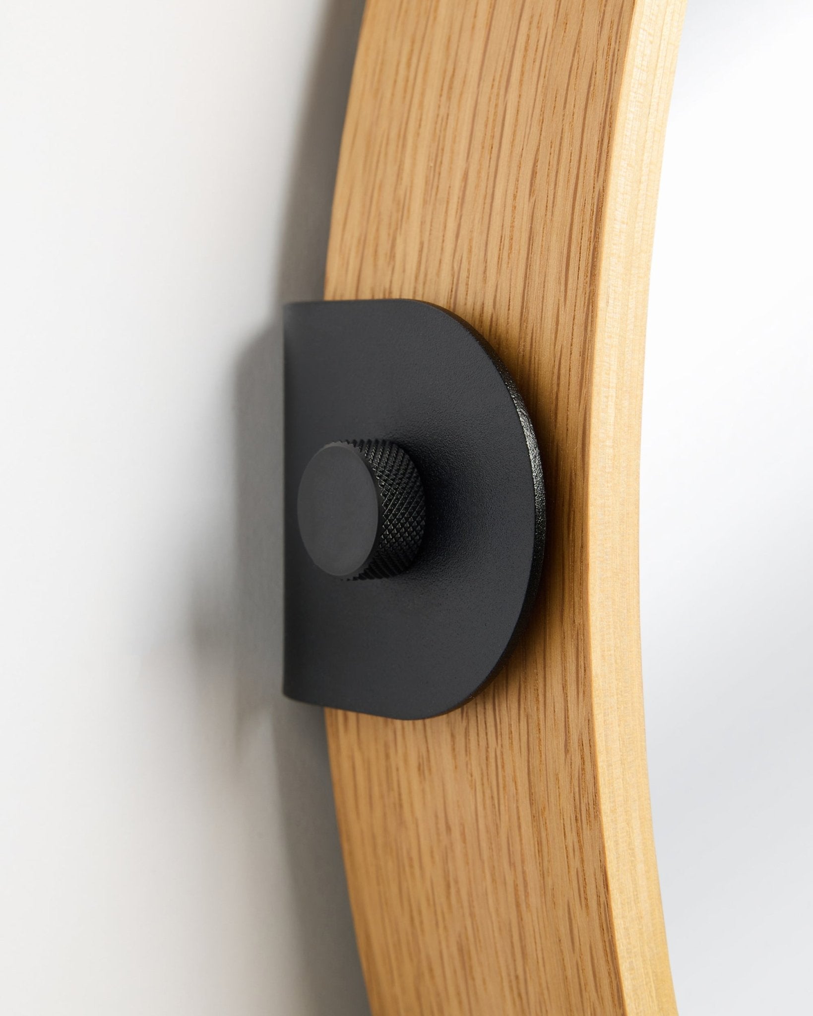 Detal lustra WoodUpp Linn w kolorze Natural Oak, akcesorium Panel akustyczny montowanego na ścianie za pomocą metalowego wspornika black i okrągłego pokrętła.