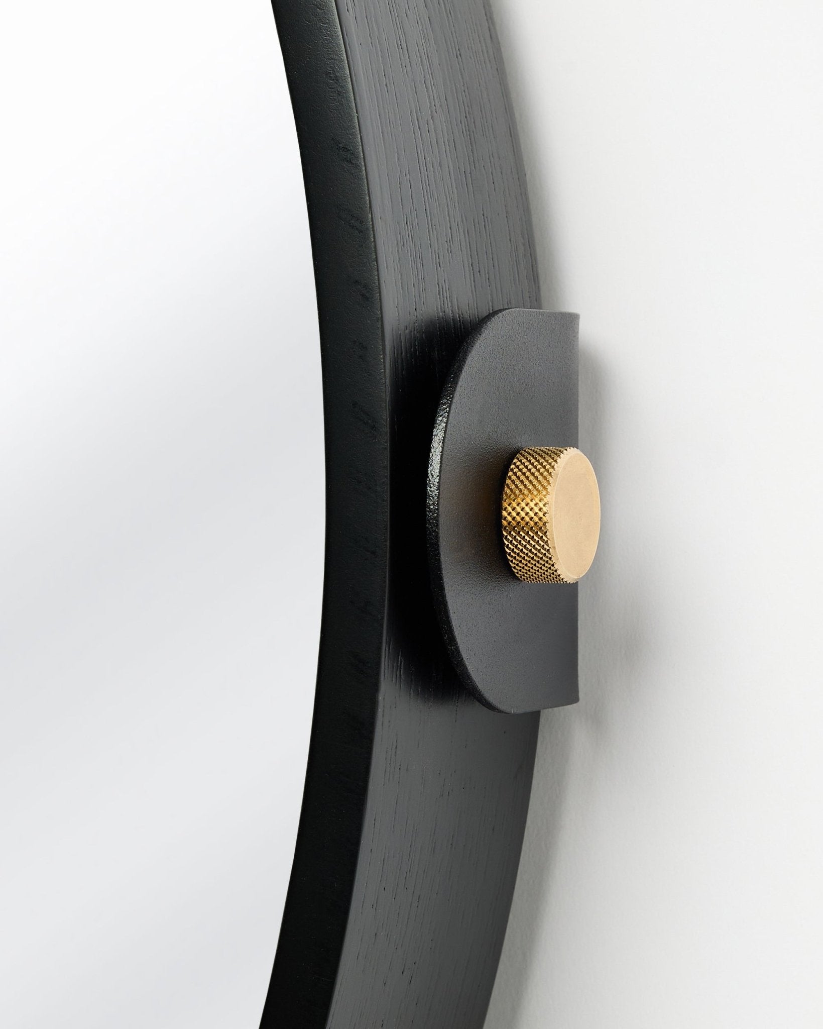 Detal Linn | Mirror / Black Oak Panel akustyczny od WoodUpp, zamontowanego na ścianie ze złotym pokrętłem i regulowanym nachyleniem.
