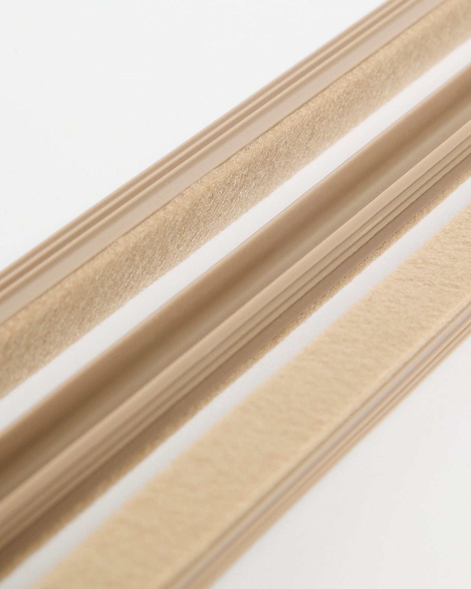 Beige osłony na kable Pop-on WoodUpp Dupps (pakiet 3 sztuk) o filcowej strukturze i z warstwą samoprzylepną, pokazane na białej powierzchni do organizacji przewodów.