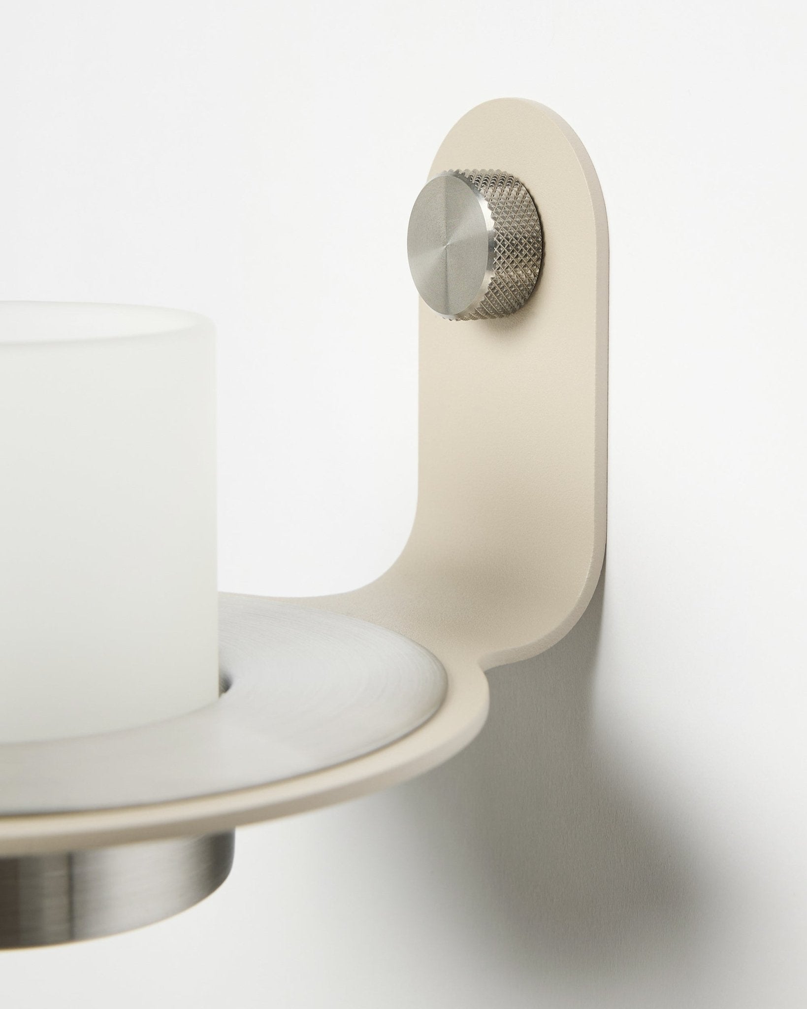 Minimalistyczny świecznik Norr w kolorze beige i ze stali nierdzewnej steel od WoodUpp, pokazany jako dodatek do paneli akustycznych z lamelami Akupanel.