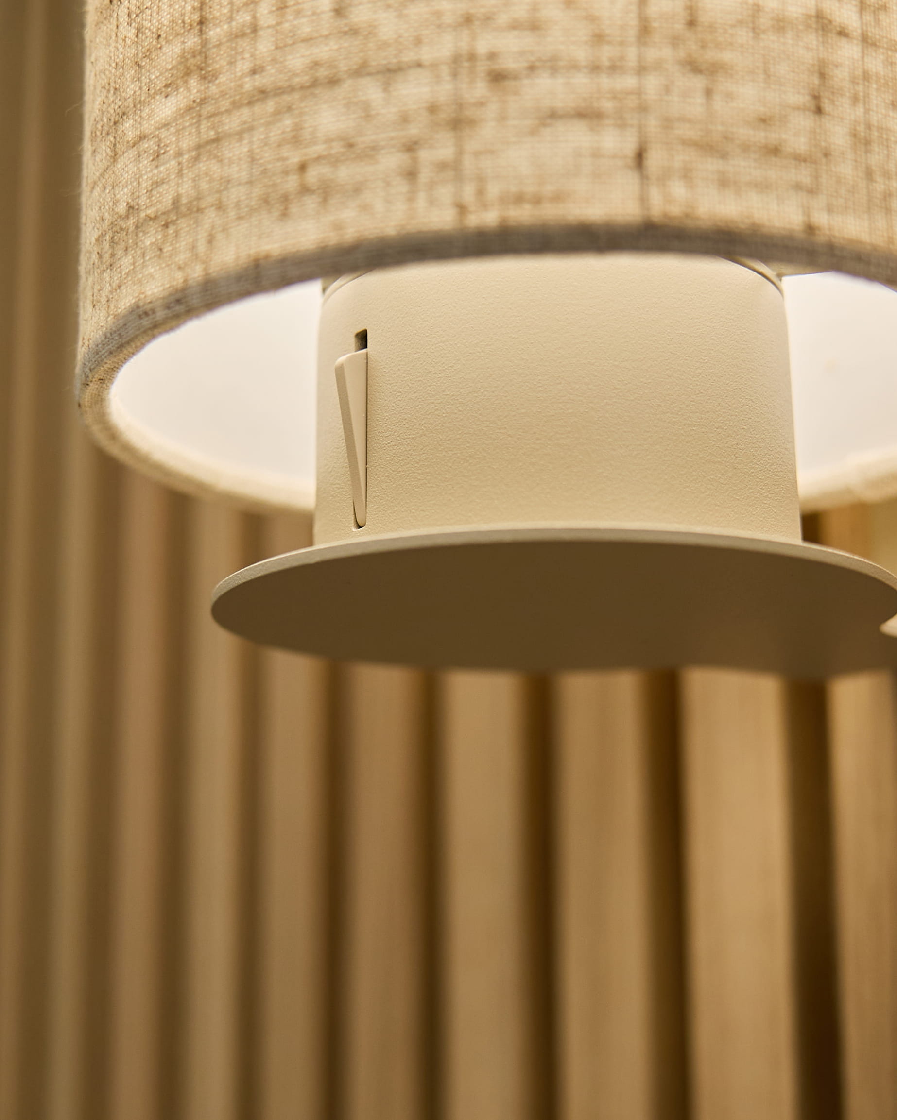 Zbliżenie na lampę ścienną Feya w kolorze Beige/Beige od WoodUpp, z abażurem z lnu i bawełny oraz cylindryczną oprawą zamontowaną na akustycznych panelach vertical beige.