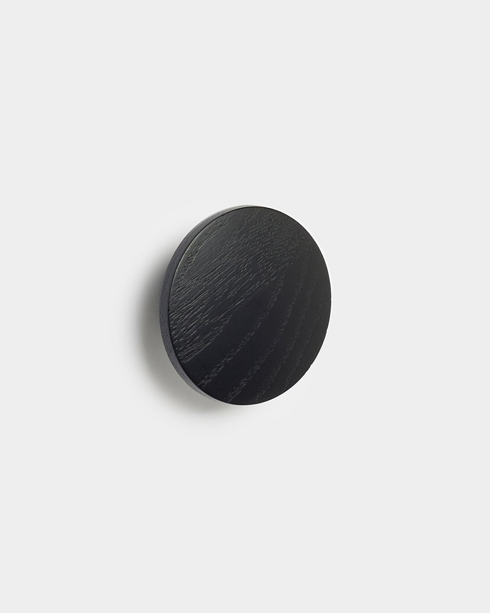 Linn | Single Hanger w kolorze black oak od WoodUpp, okrągły dodatek do paneli akustycznych Akupanel, pokazany na jednolitym białym tle.