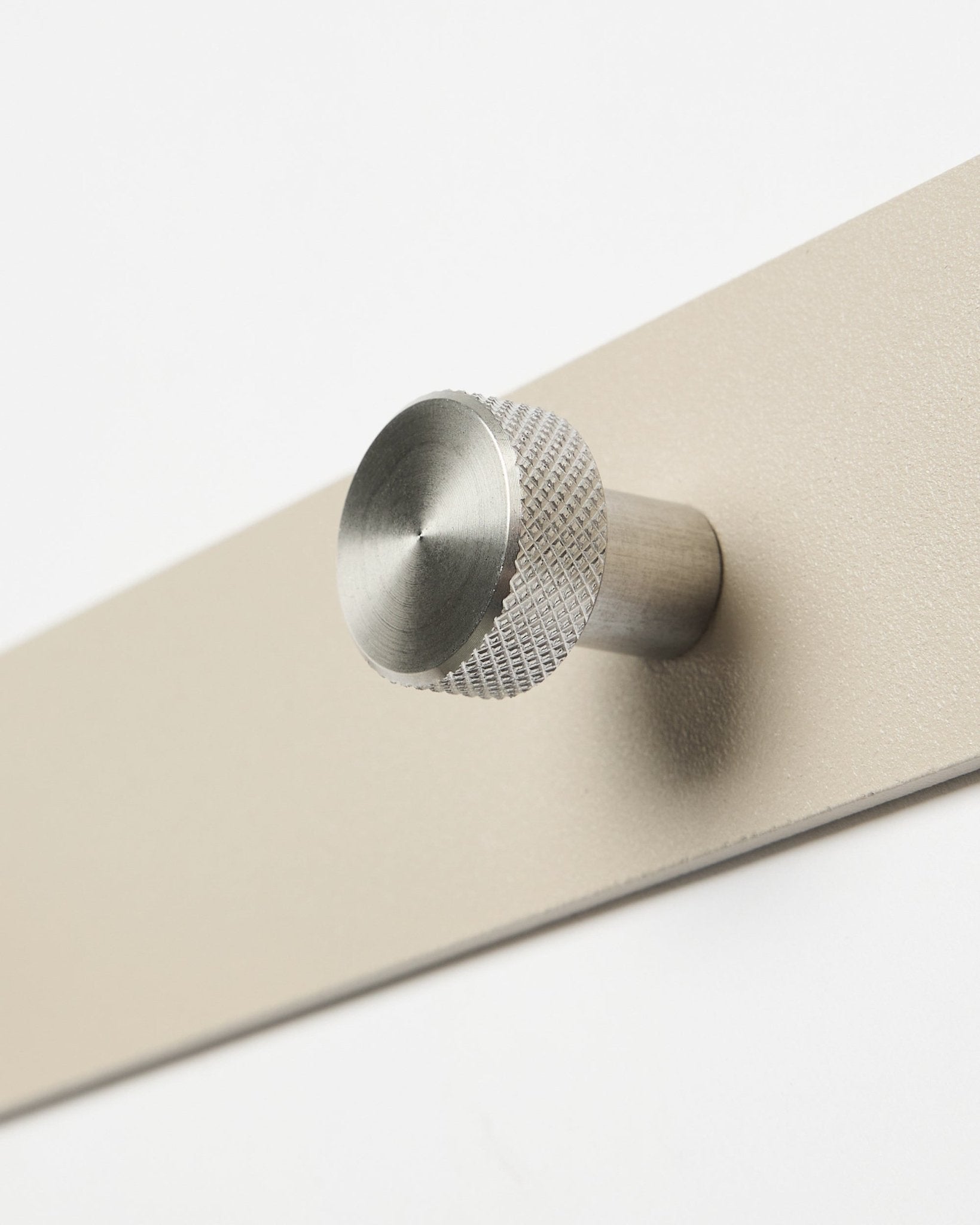 Zbliżenie na WoodUpp Norr Coat Hook Rack w kolorze beige i ze stali nierdzewnej steel, X7, zaprojektowany jako akcesorium do akustycznych paneli drewnianych Akupanel lub do organizacji w przedpokoju.