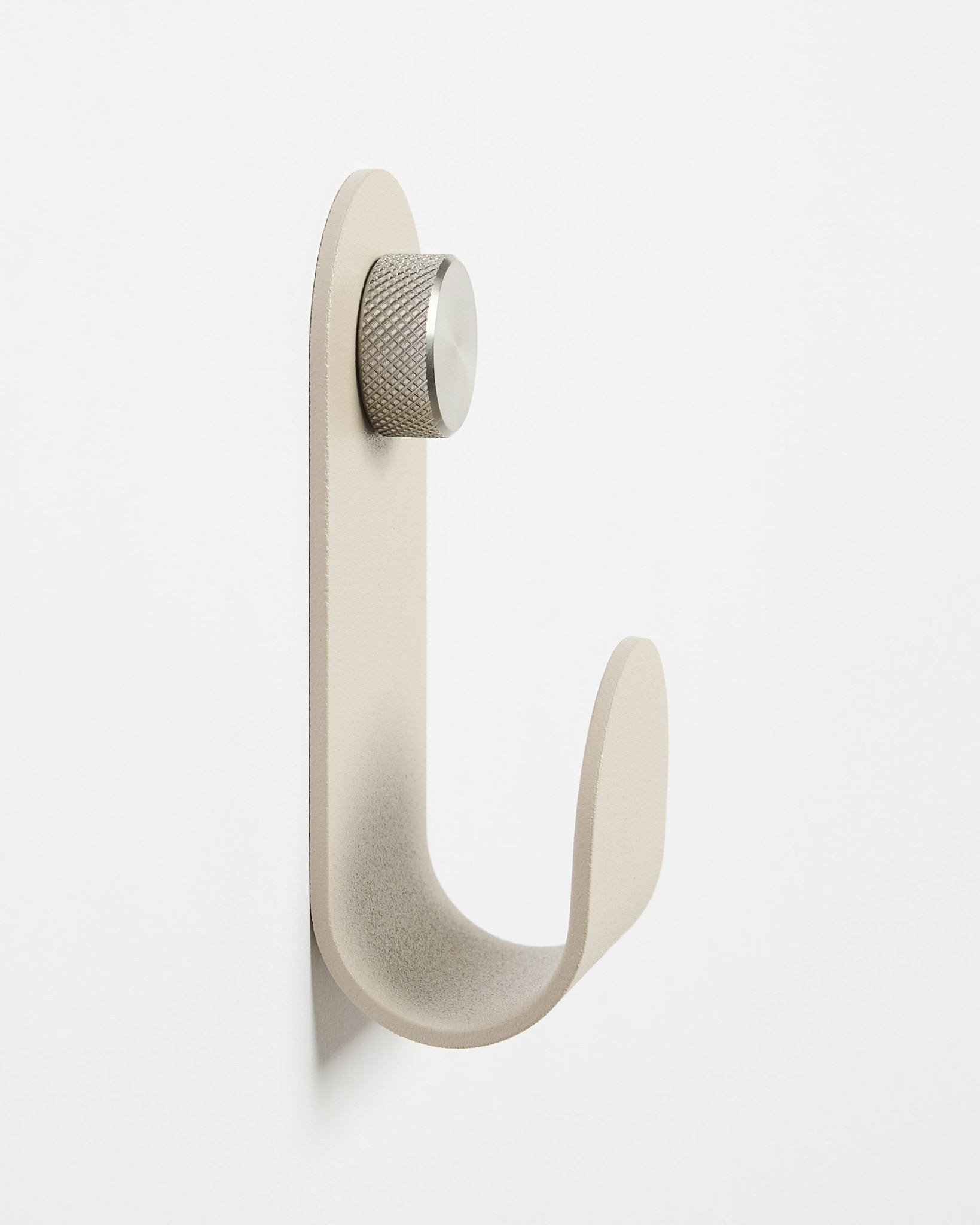 Norr | Single Hanger w kolorze Beige od WoodUpp to minimalistyczne akcesorium ścienne z srebrnym pokrętłem, zaprojektowane jako uzupełnienie akustycznych paneli drewnianych Akupanel.