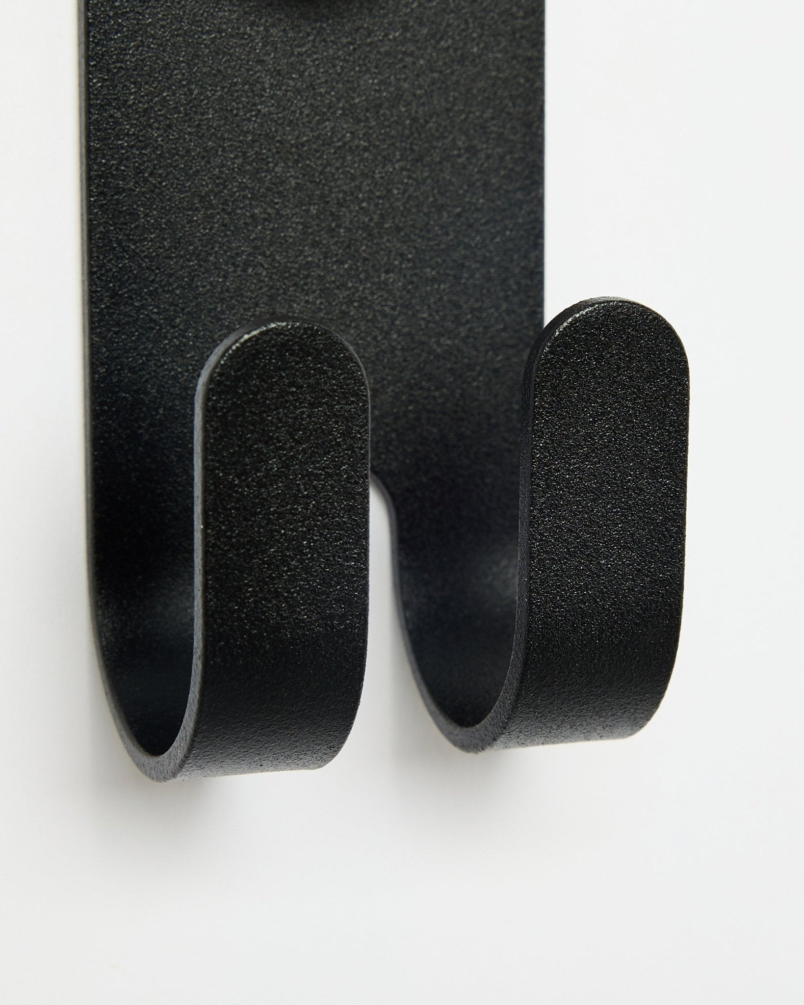 Zbliżenie na Norr Double Hanger w kolorze black od WoodUpp, pokazujące podwójne haczyki przeznaczone do akcesoriów Akupanel na białym tle.