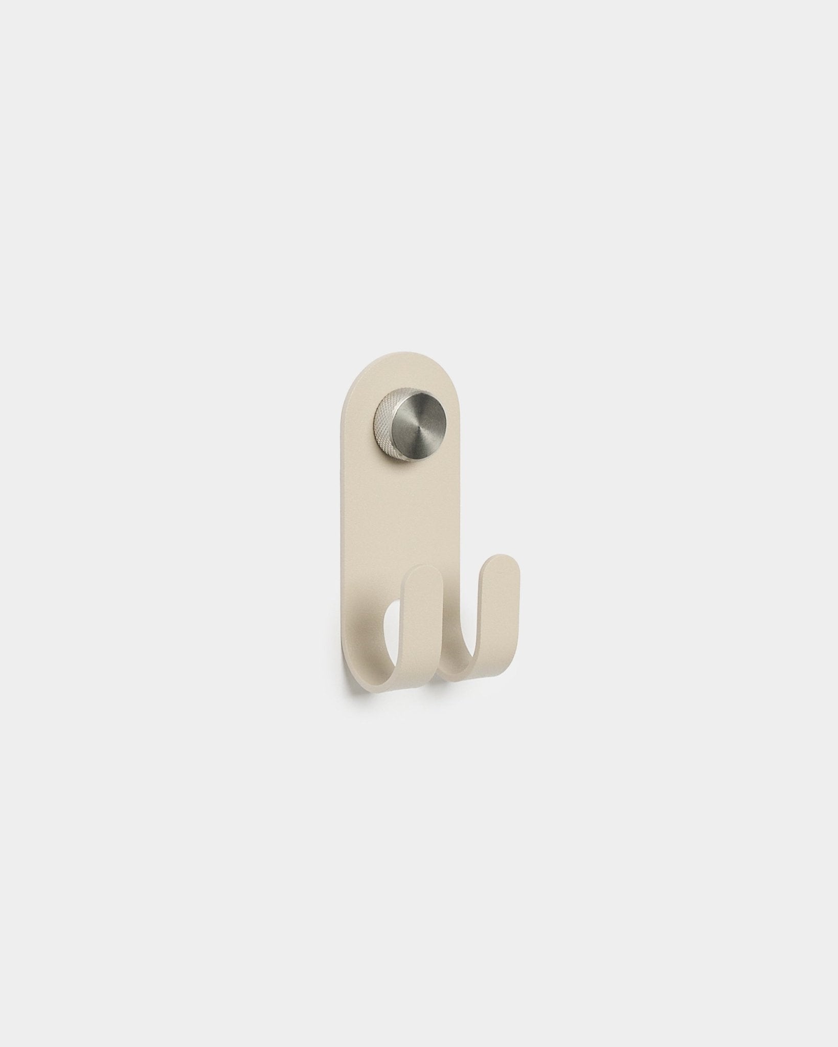 WoodUpp Norr Double Hanger w kolorze beige z dwoma metalowymi haczykami i okrągłym srebrnym pokrętłem, minimalistyczny nordycki design, na jednolitym białym tle.