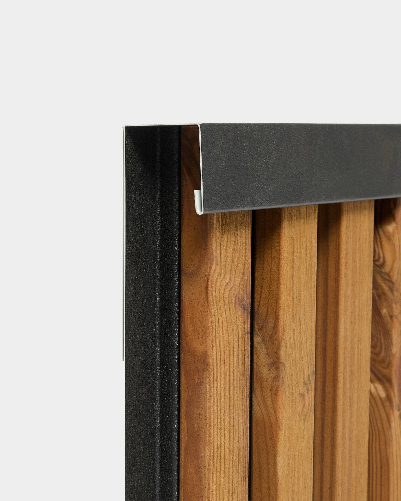Zbliżenie na profil wykończeniowy WoodUpp Aluwood 240 cm z aluminiową krawędzią black do zewnętrznych paneli elewacyjnych, pokazany na białym tle.