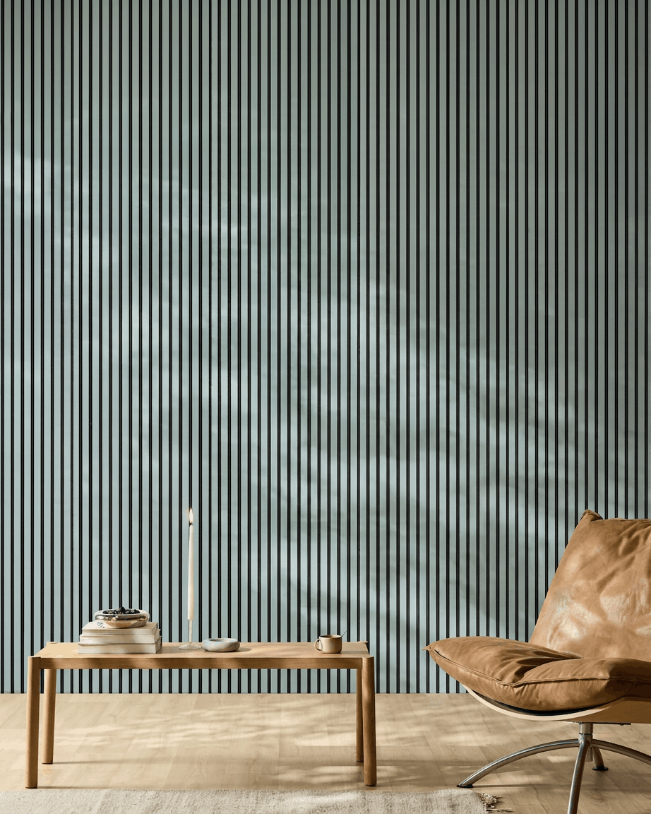 Minimalistyczne wnętrze z drewnianą ławką, książkami i skórzanym fotelem brown przed WoodUpp Akupanel Panel akustyczny w kolorze Cloud z filcem black.