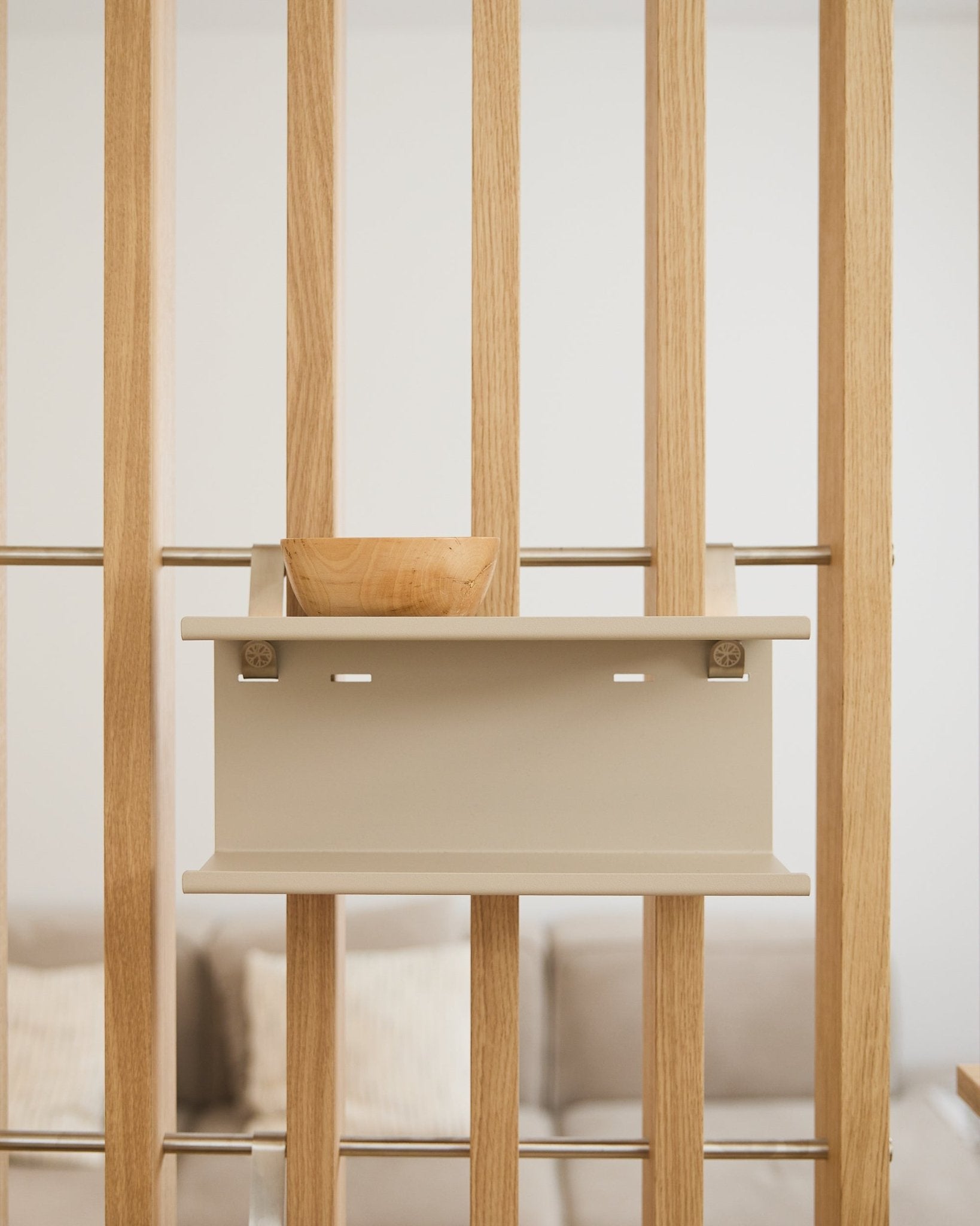 small drewniana misa na półce beige Nell Double Metal Shelf od WoodUpp (31,7 cm), z rozmytą sofą i poduszkami w tle.