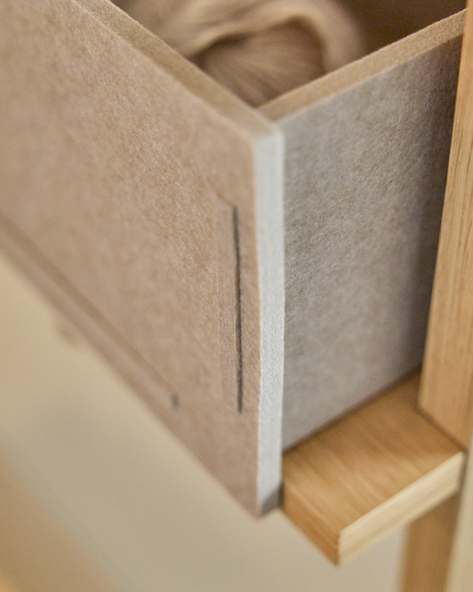 Vigg Felt Box / BM2 w kolorze Beige od WoodUpp to szuflada z filcu PET z drewnianą ramą, zaprojektowana z myślą o przechowywaniu w neutralnej tonacji i kompatybilna z systemami Akupanel.