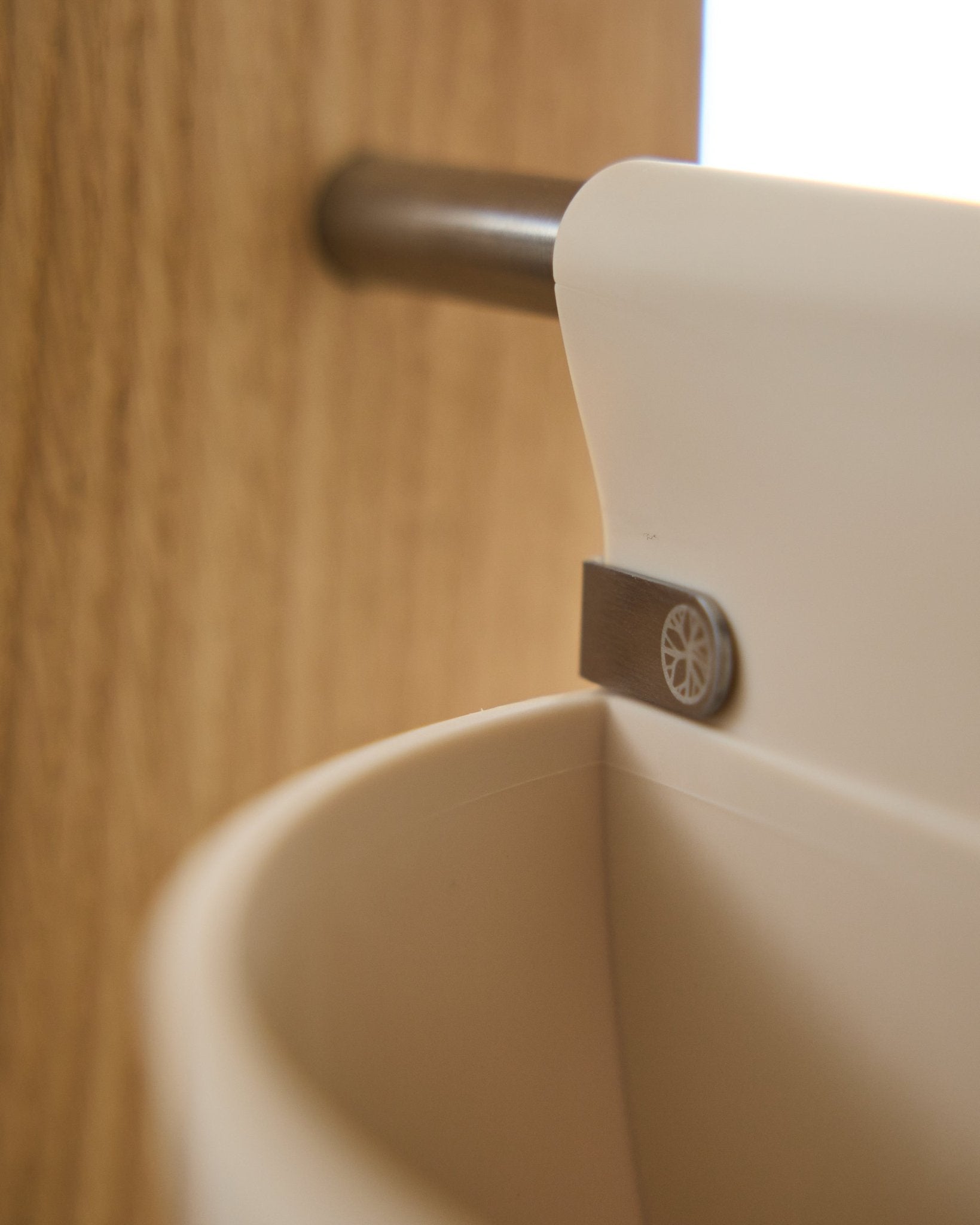 Zbliżenie na Gro | Soft Pocket / BM2 (4 l) w jasnym odcieniu beige od WoodUpp, zawieszony na metalowym pręcie zamocowanym do drewna; tło jest rozmyte. Nordyckie akcesorium akustyczne.